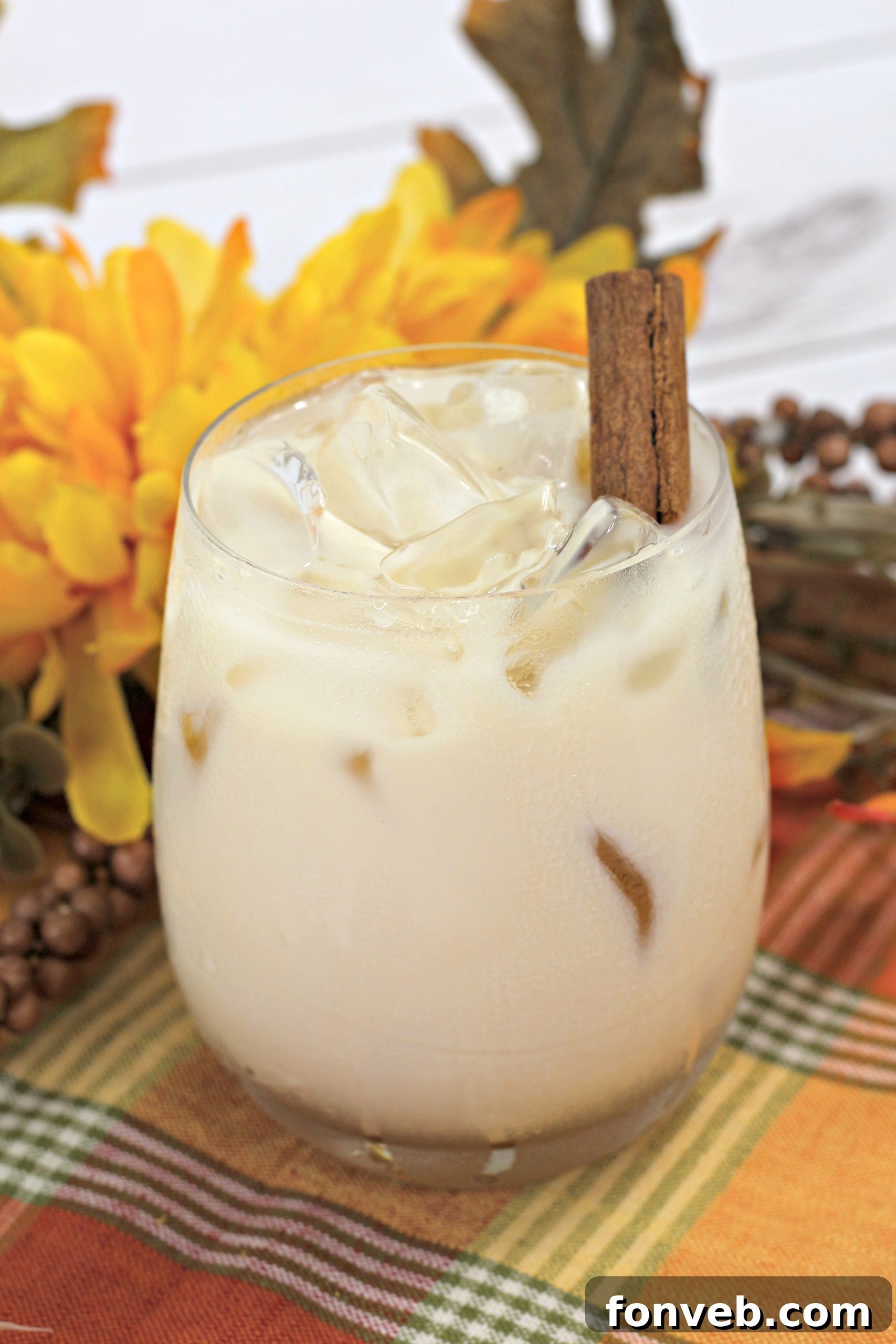 Creamy Pumpkin Spice White Russian cocktail in a glass with ice and cinnamon stick garnish