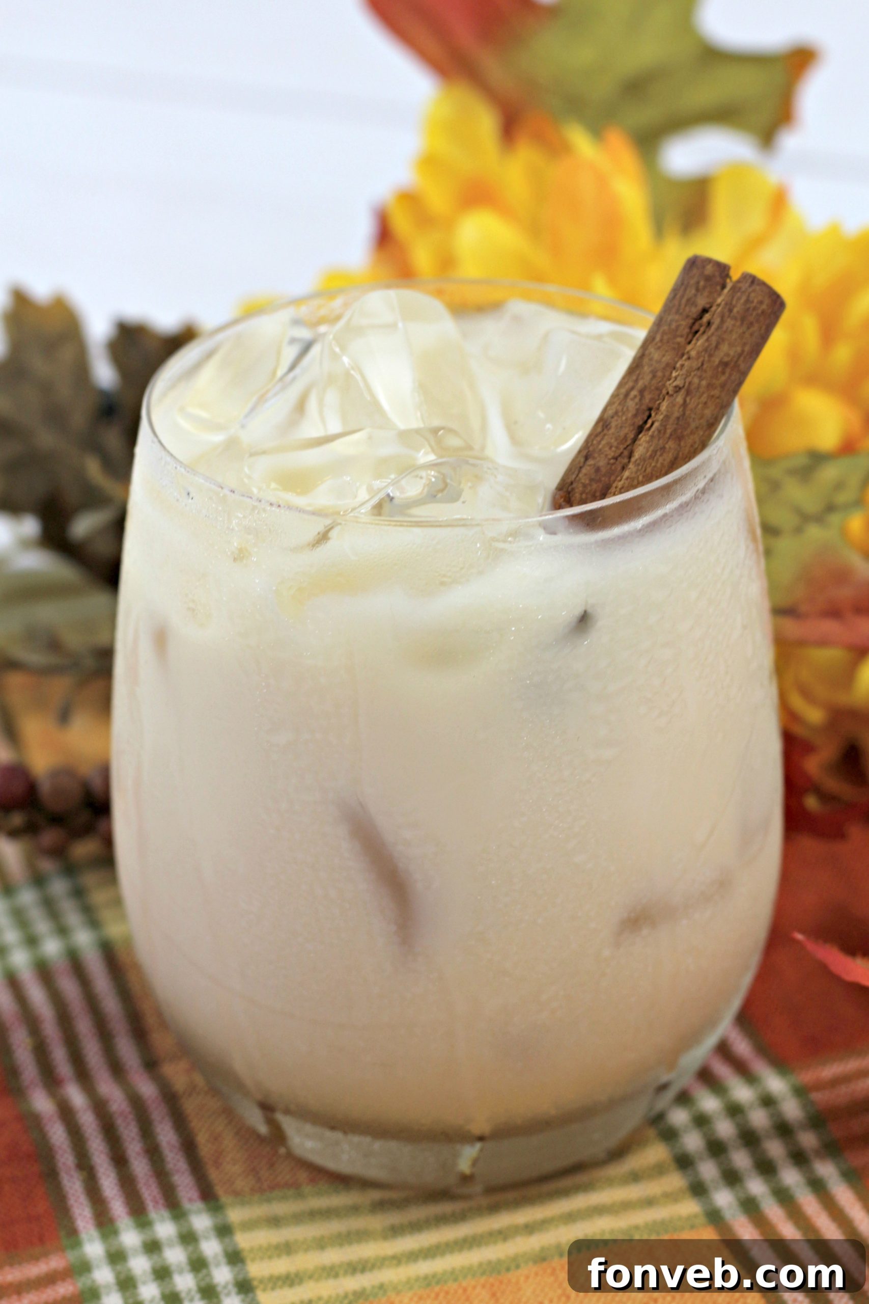 Two glasses of Pumpkin Spice White Russian cocktails with fall decorations, ready to be served for autumn gatherings