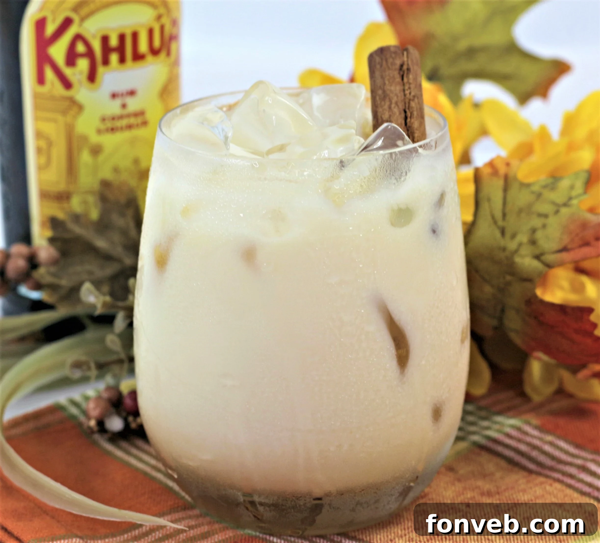 A festive Pumpkin Spice White Russian cocktail adorned with a cinnamon stick, beautifully presented for a fall celebration.