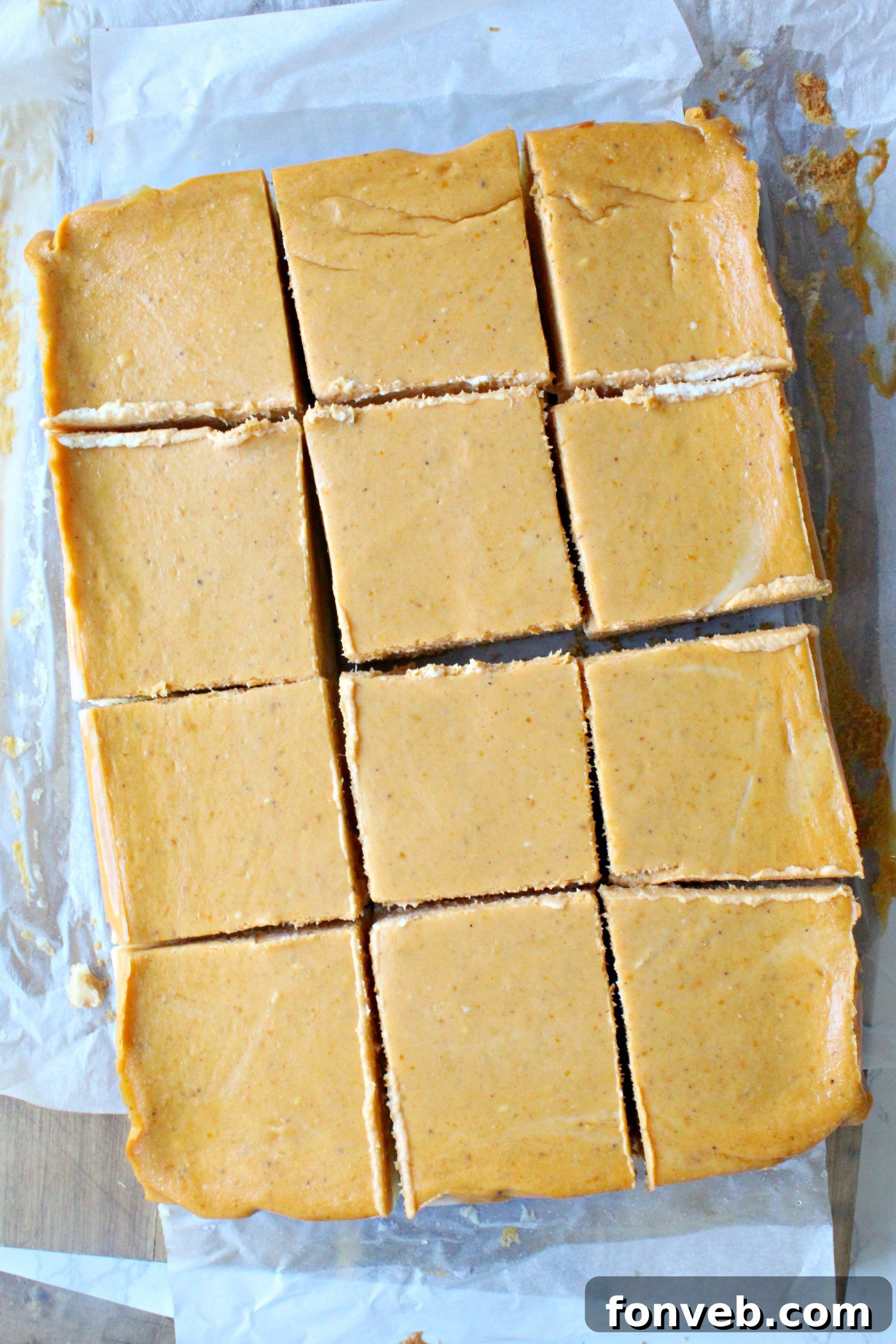 A vibrant selection of ingredients for Pumpkin Cheesecake Bars displayed on a rustic wooden table