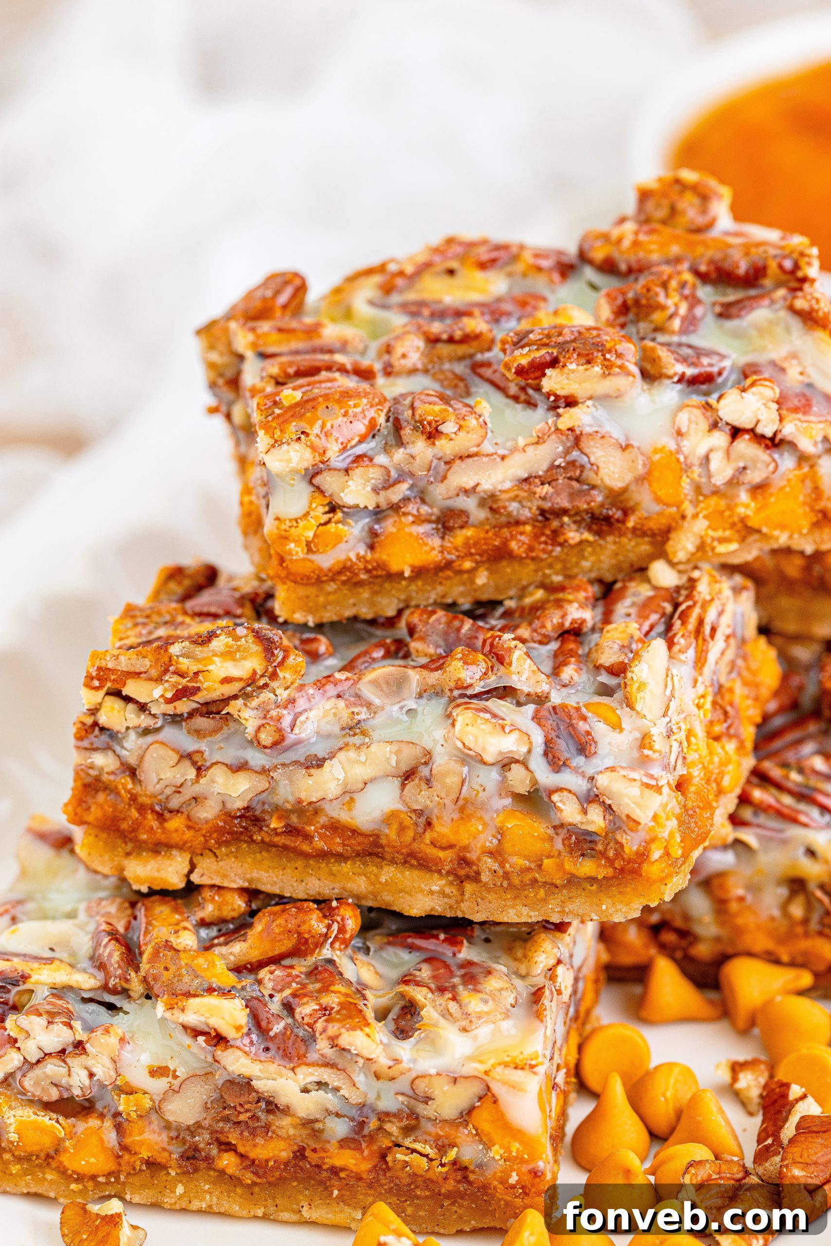 A close-up of a single Pumpkin Pecan Magic Bar with a bite taken, revealing the moist interior, crunchy nuts, and gooey butterscotch. A sensational fall dessert.
