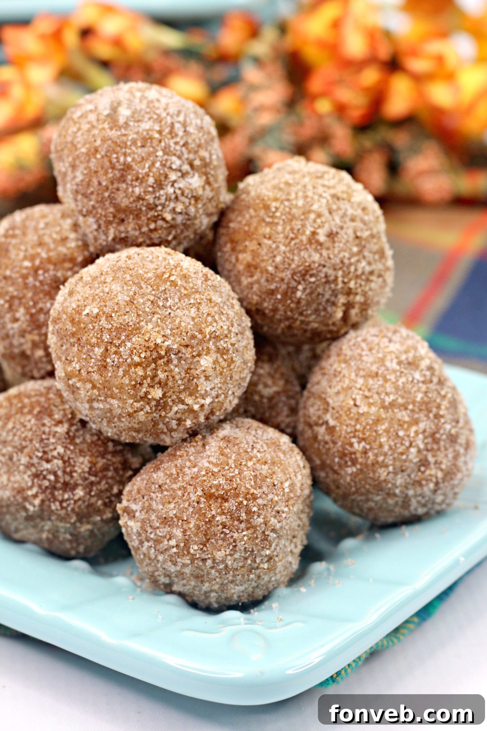 Assortment of pumpkin snickerdoodle donut holes arranged on a serving plate