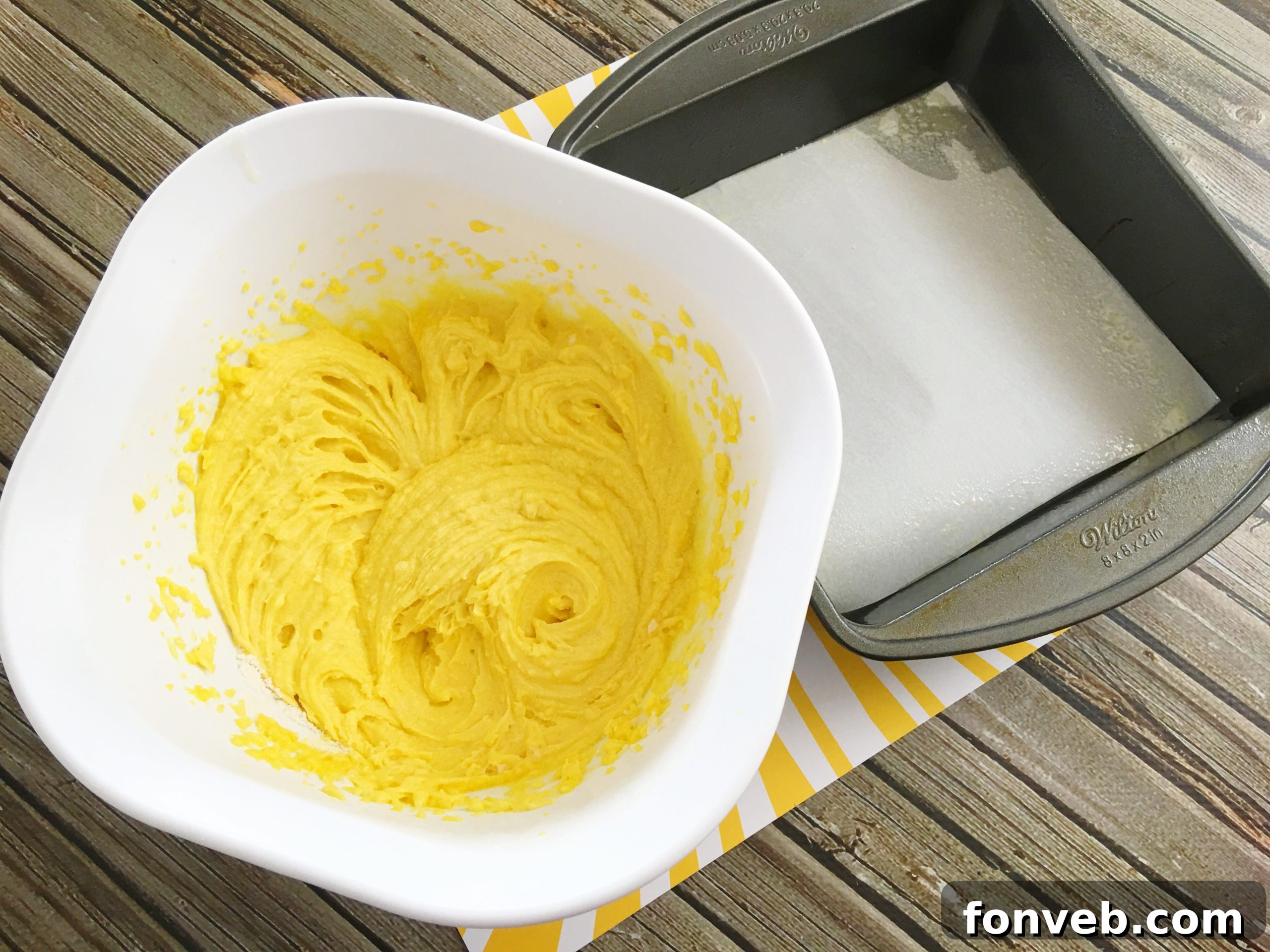 Hand reaching for a lemon cream cheese brownie slice