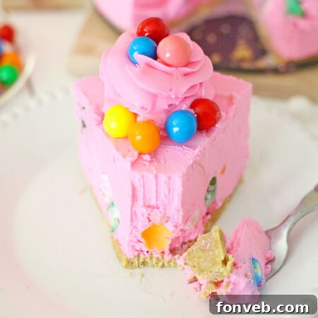 A slice of Bubblegum Cheesecake on a white plate with a fork