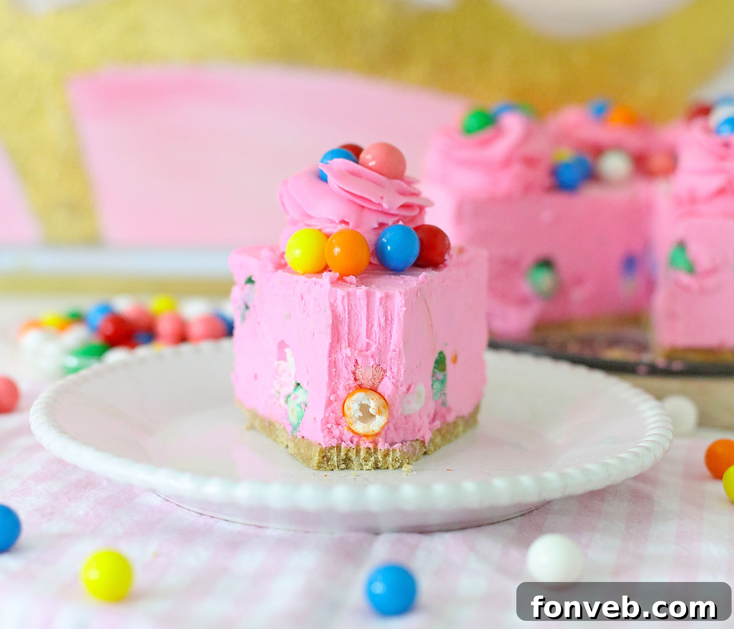 A close-up shot of the vibrant pink piped frosting, demonstrating the technique of rolling plastic wrap around the frosting to load it into a pastry bag.