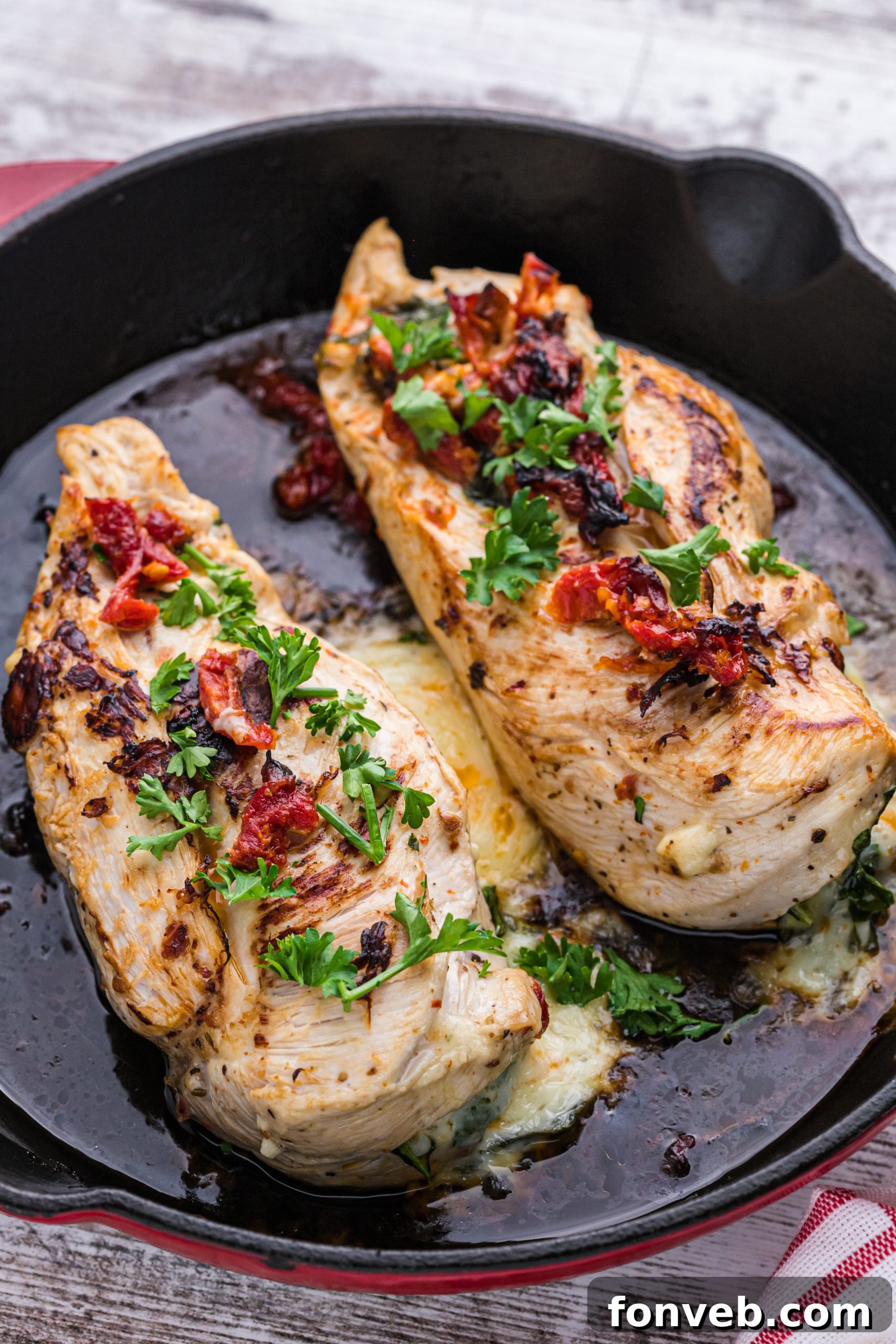 Moist and tender cheesy spinach and sundried tomato stuffed chicken breast on a plate