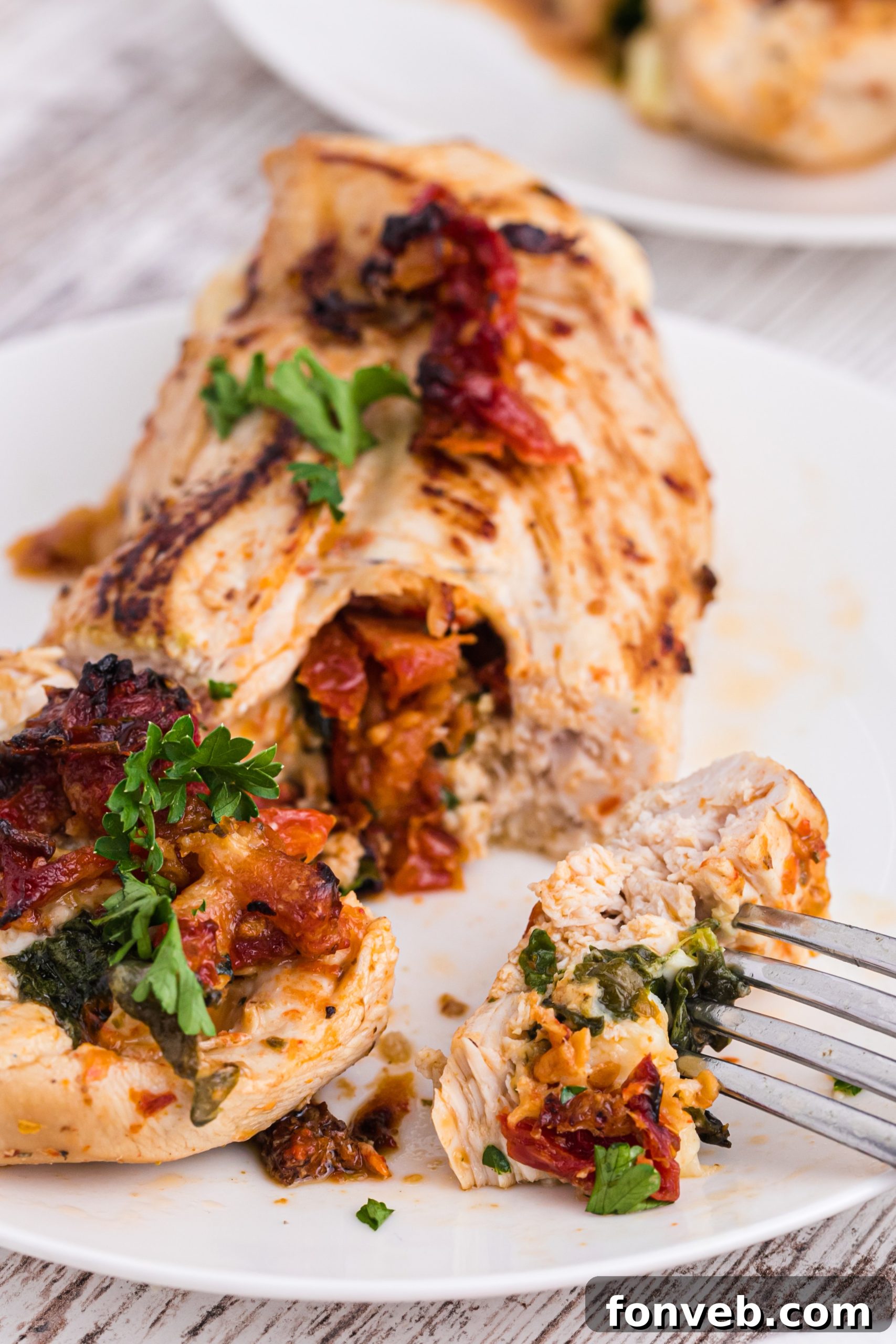 A serving of stuffed chicken with a side of pasta and green vegetables