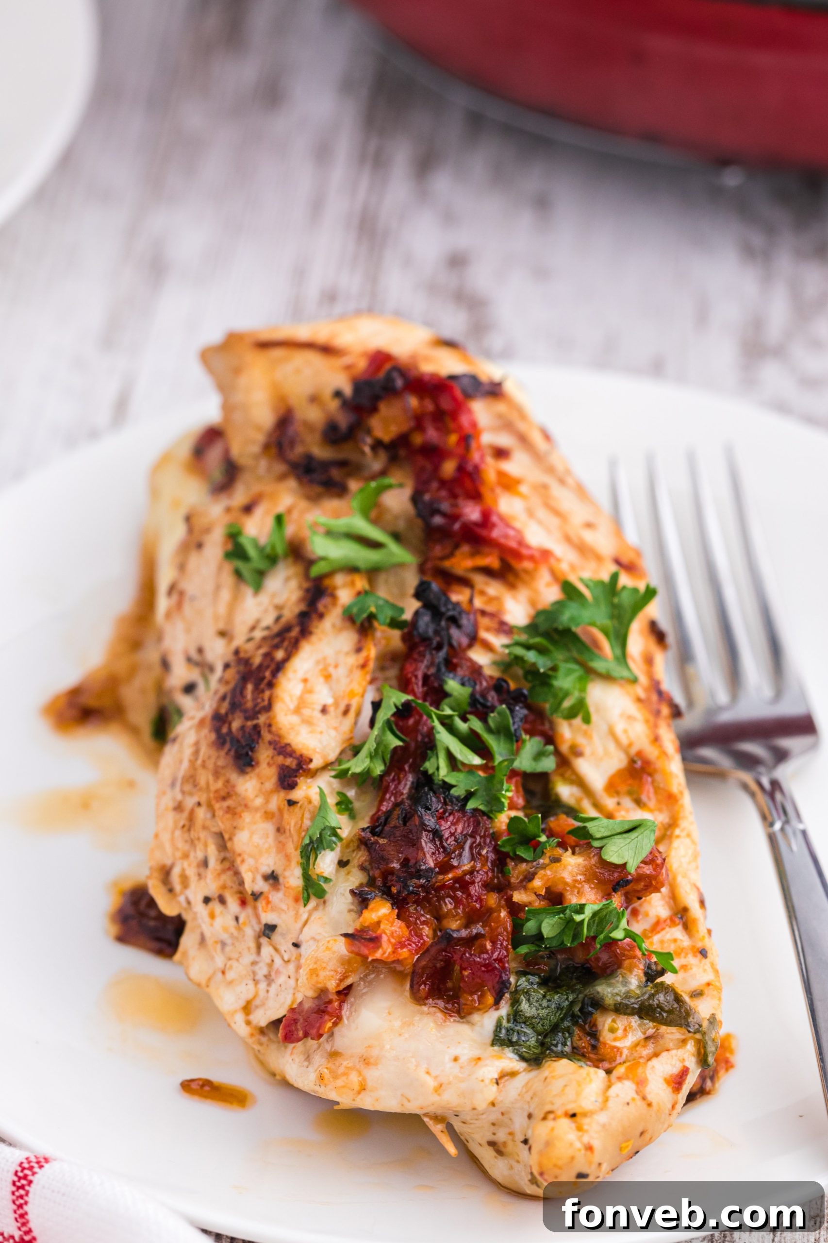 Two plates of stuffed chicken, perfectly cooked and garnished