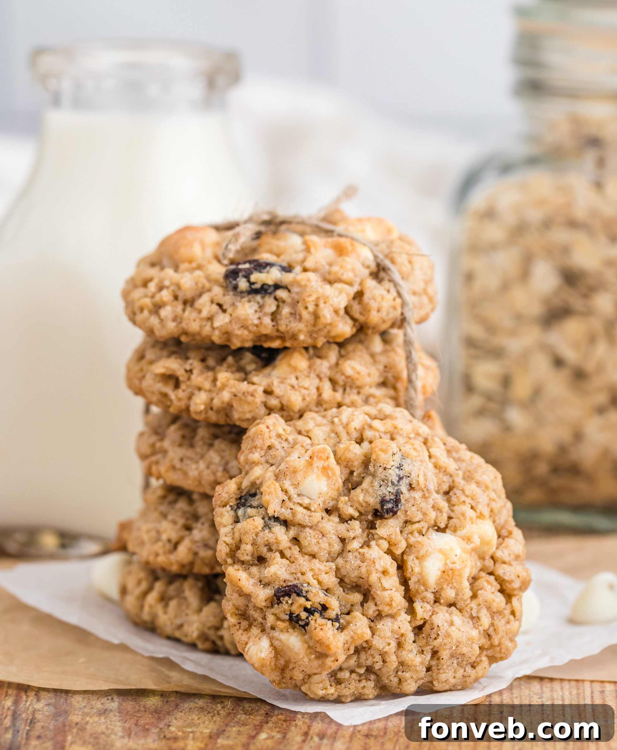 A plate of oatmeal raisin cookies with a glass of milk