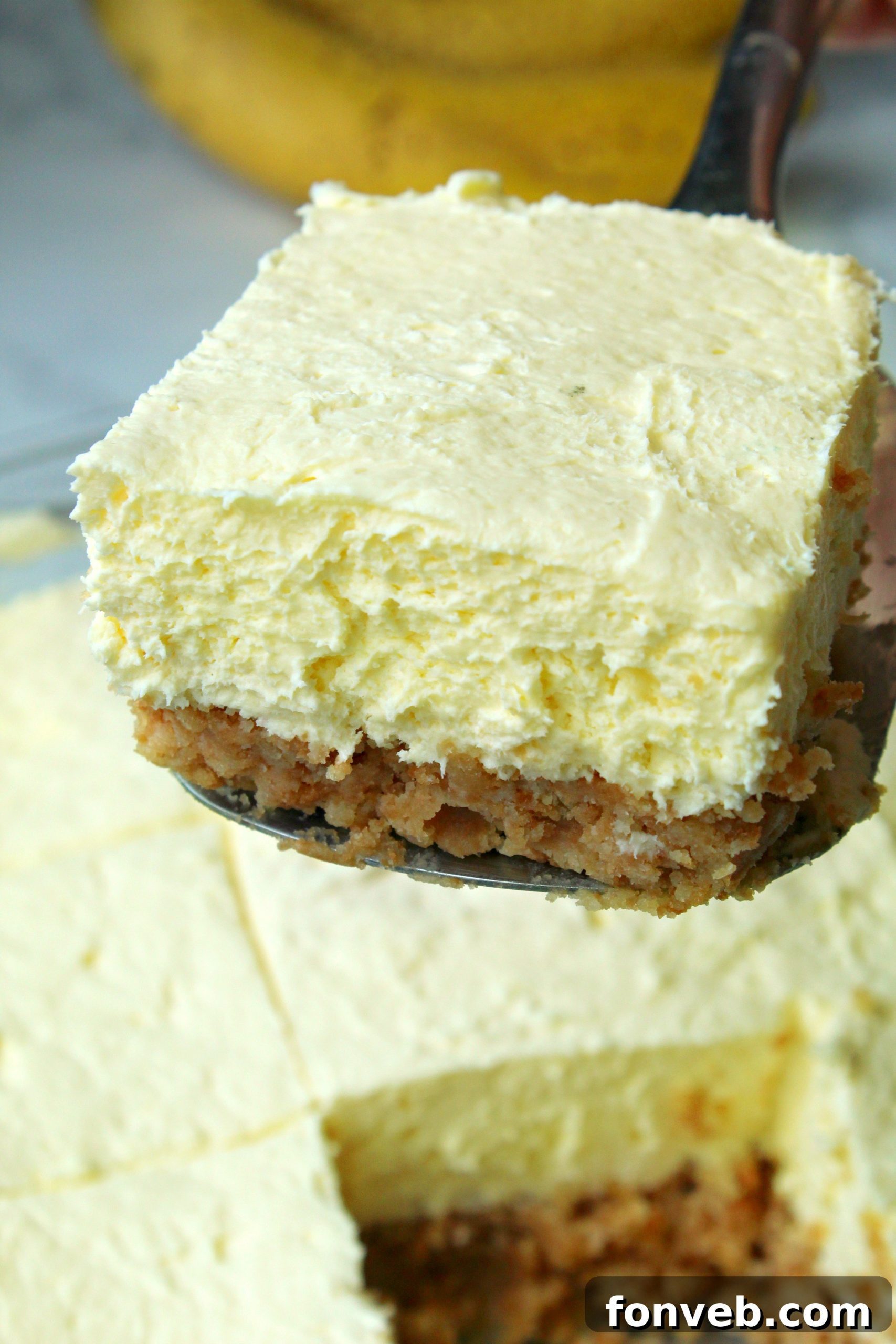 Assortment of ingredients for Banana Cream Cheesecake Bars: Nilla wafers, cream cheese, heavy cream, butter, and instant pudding mix, laid out on a wooden surface.