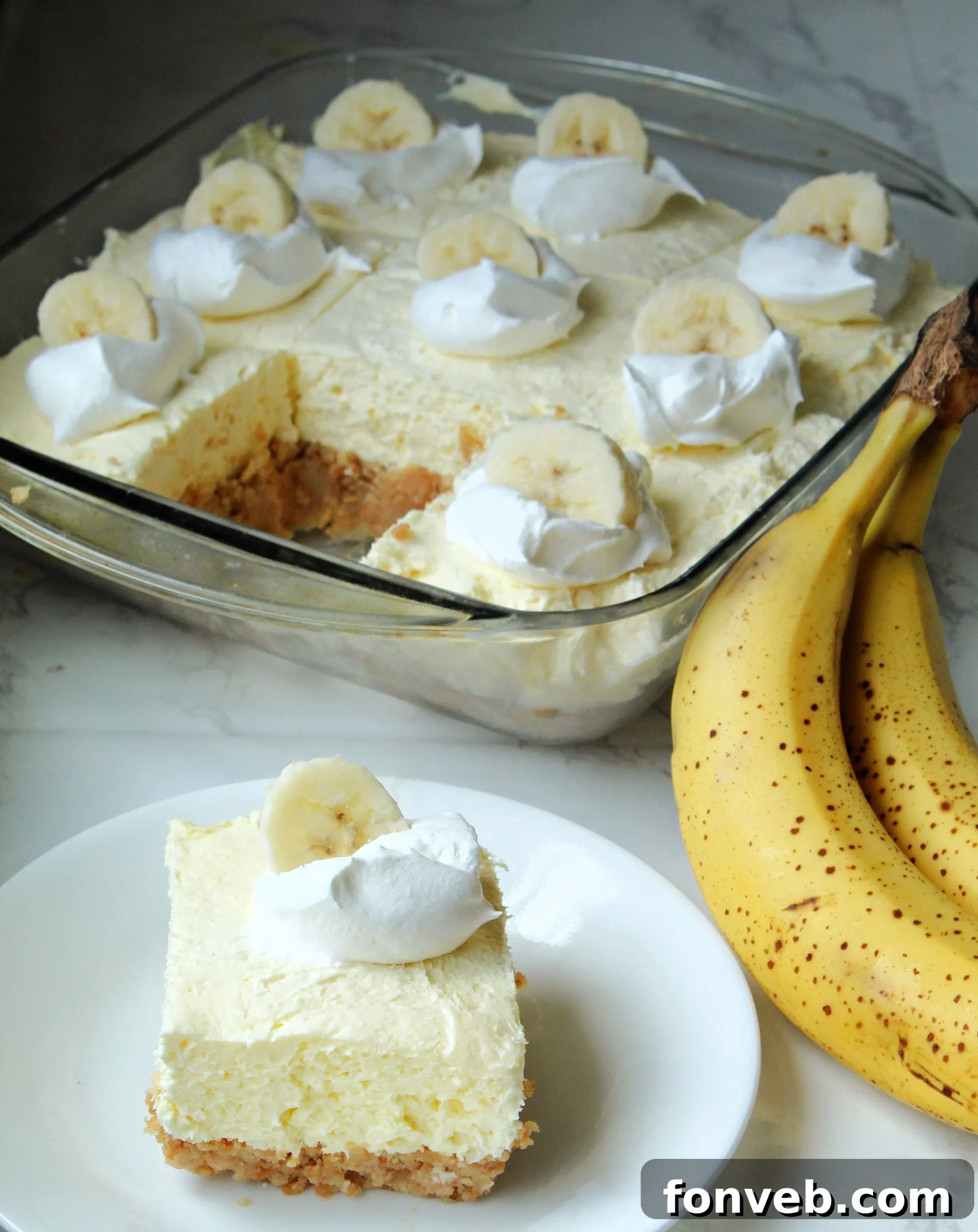 A vibrant display of freshly prepared Banana Cream Cheesecake Bars, beautifully garnished with whipped cream and banana slices, ready to be enjoyed.