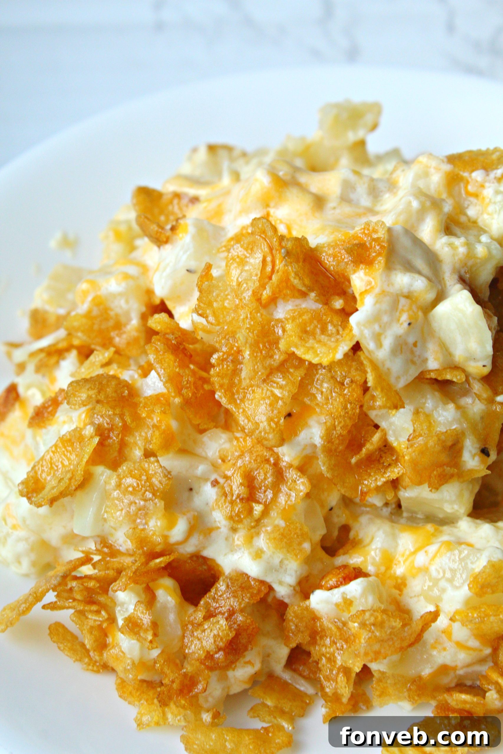 A plate piled high with Funeral Potatoes, showing the hearty portion size and appetizing texture