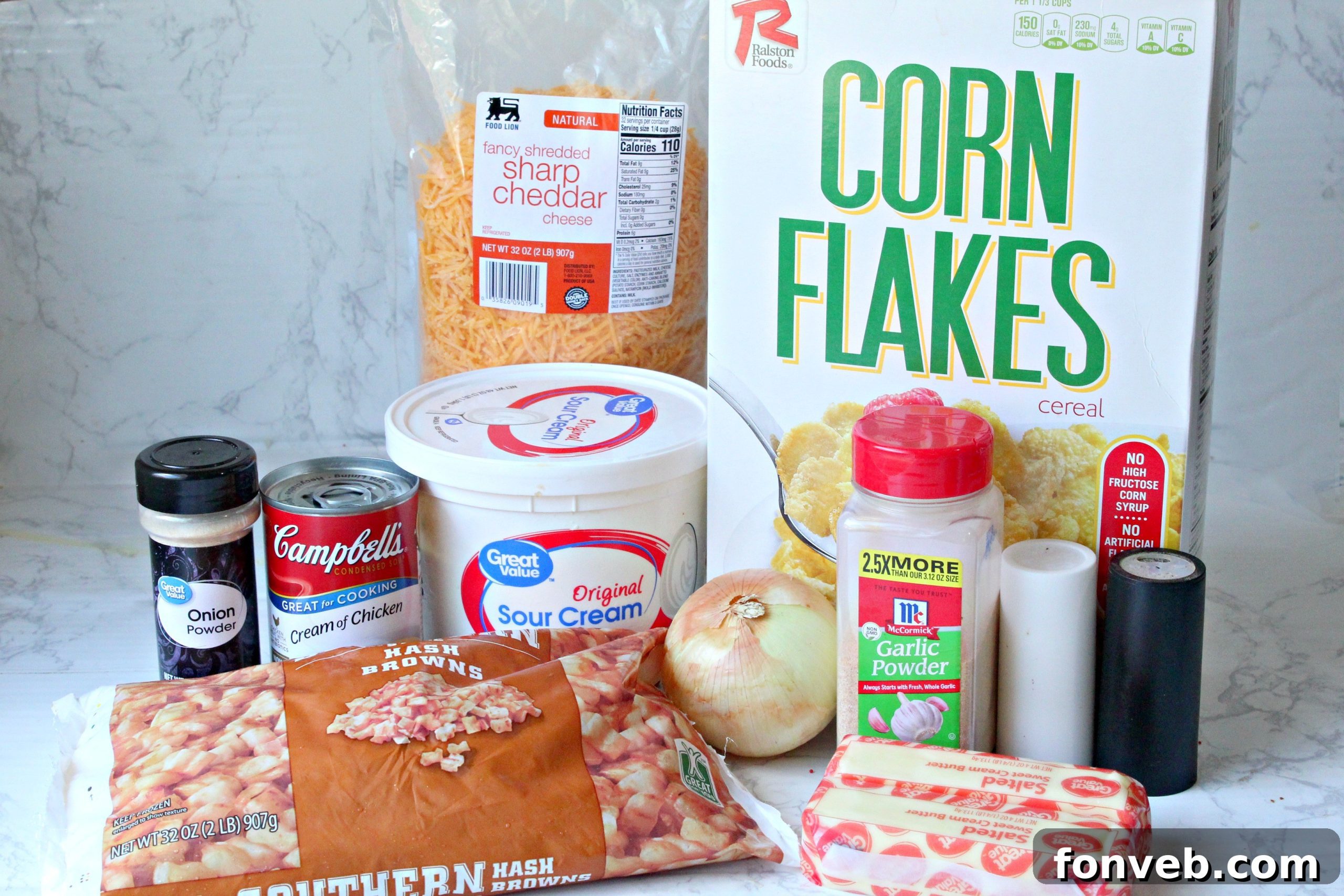 Fresh ingredients for Funeral Potatoes laid out on a table, including hash browns, cheese, and sour cream