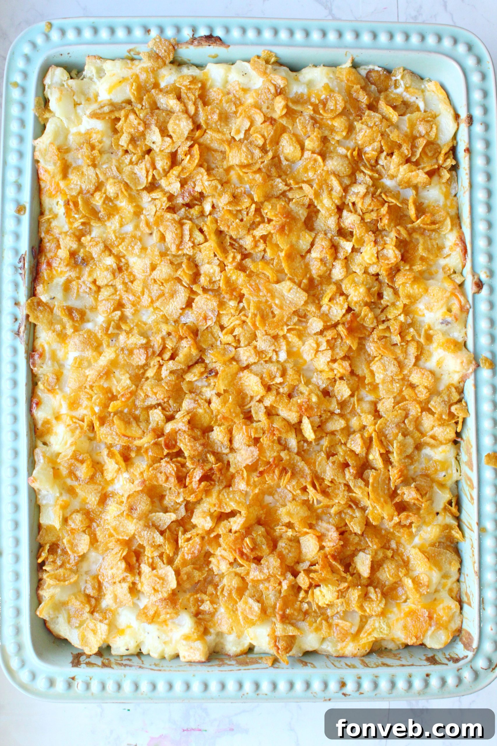 Overhead shot of a full baking pan of Funeral Potatoes, with a golden-brown cornflake crust