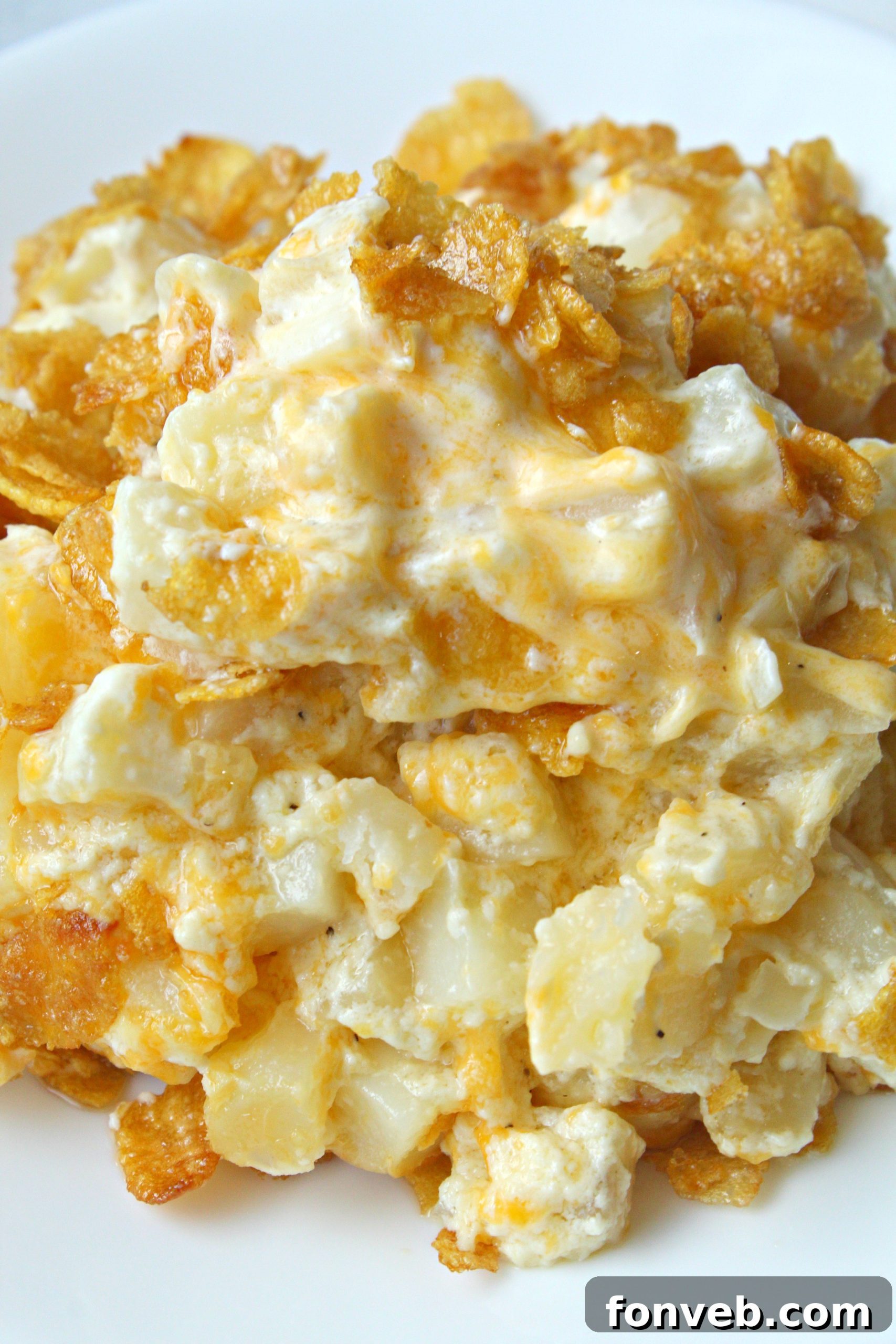 Close-up of Funeral Potatoes on a plate, highlighting the creamy texture and cornflake crunch