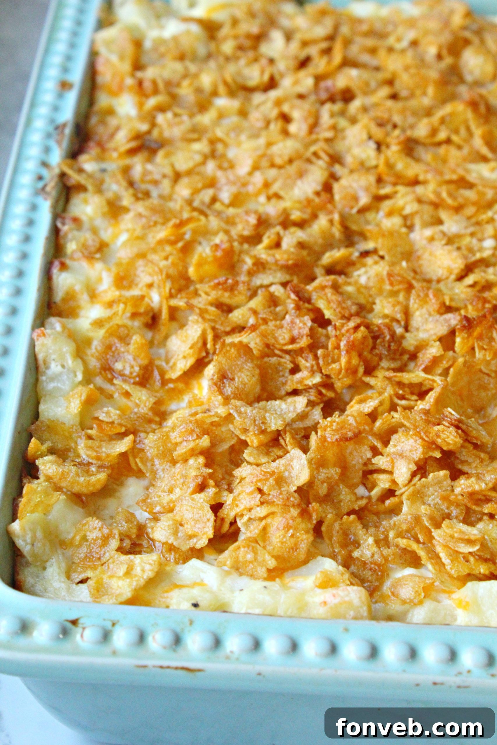 Funeral Potatoes in a baking pan, topped with crushed cornflakes before baking