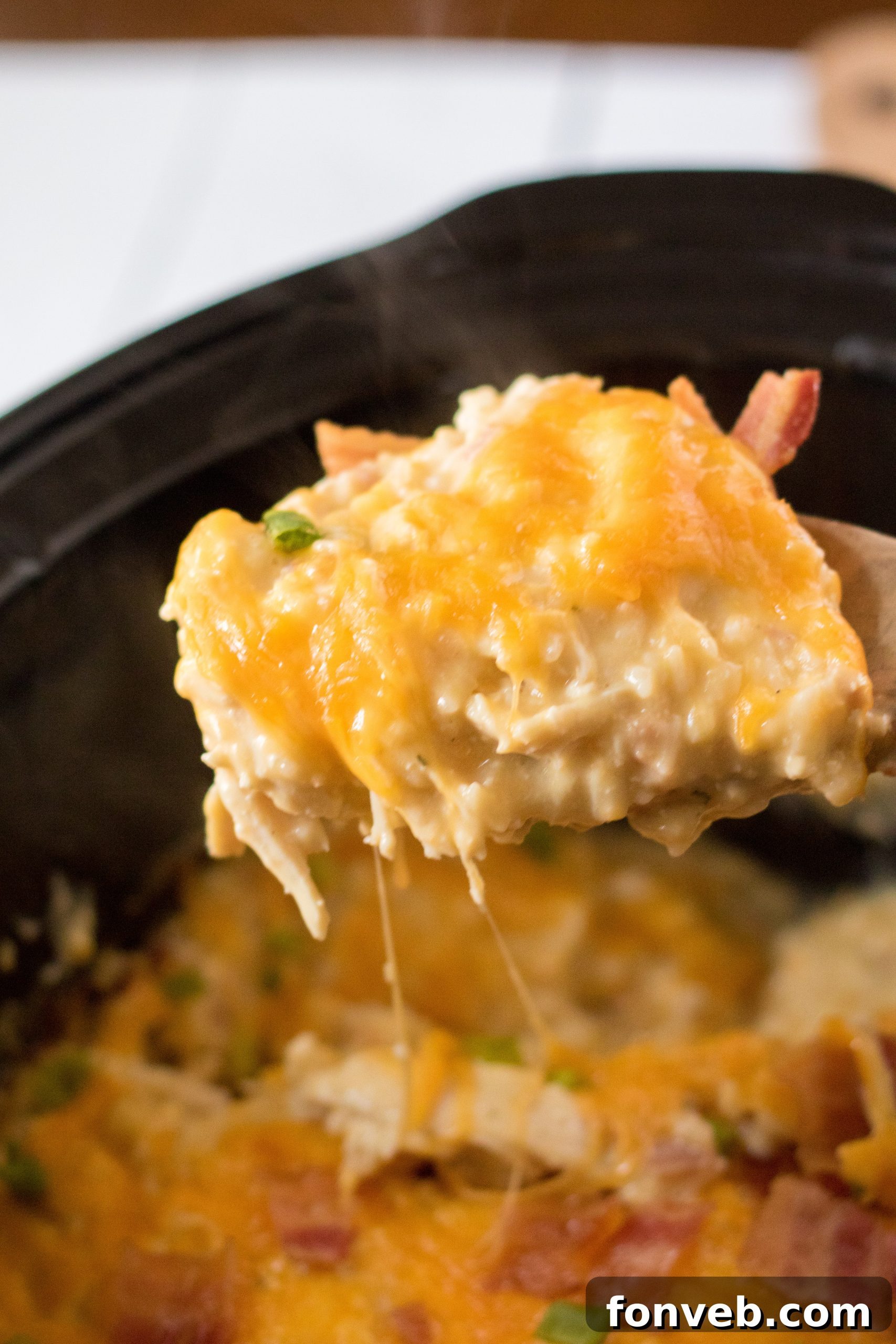 Slow Cooker Cheesy Crack Chicken and Rice, topped with melted cheese and crispy bacon bits, ready to serve.