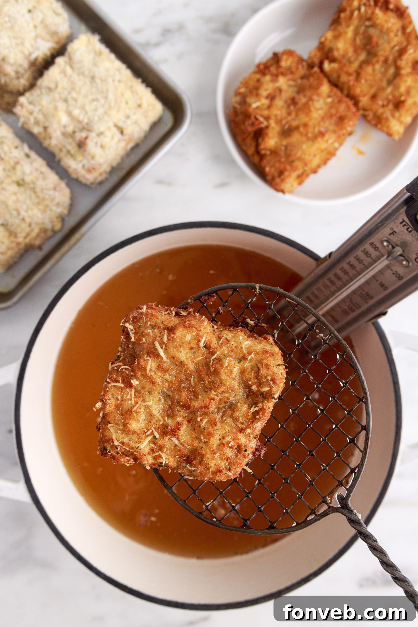 Golden Lasagna Crunch 4 Hand dipping a lasagna square into breadcrumbs