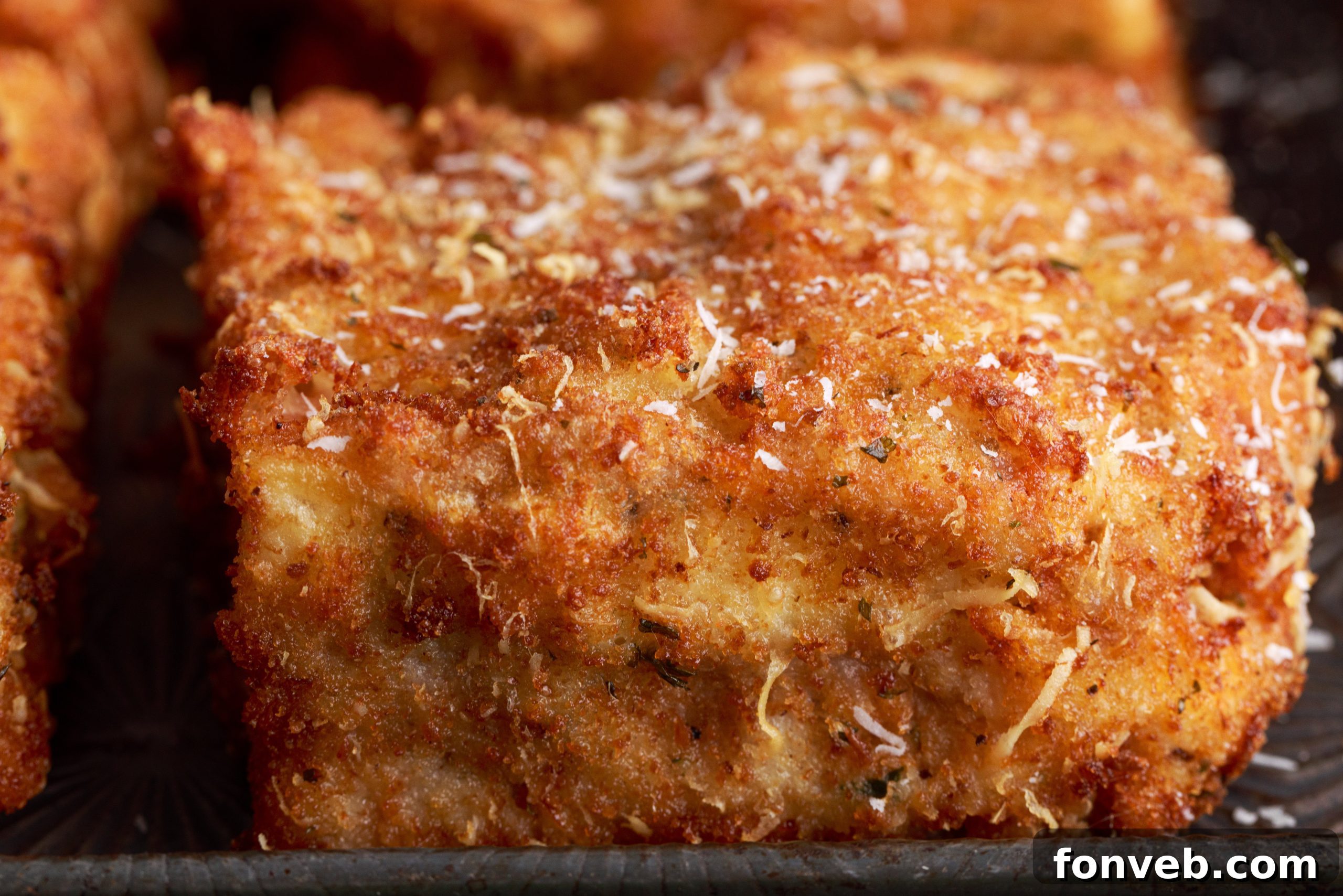 Golden Lasagna Crunch 6 Close-up of a deep fried lasagna square being fried in oil