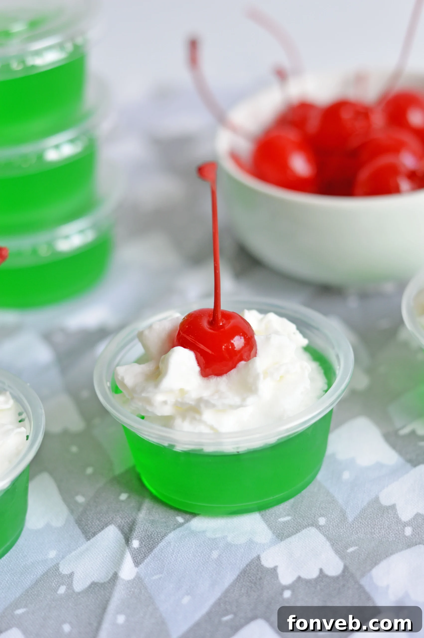 Arrangement of Grinch Jello Shots, some with cherries, some without