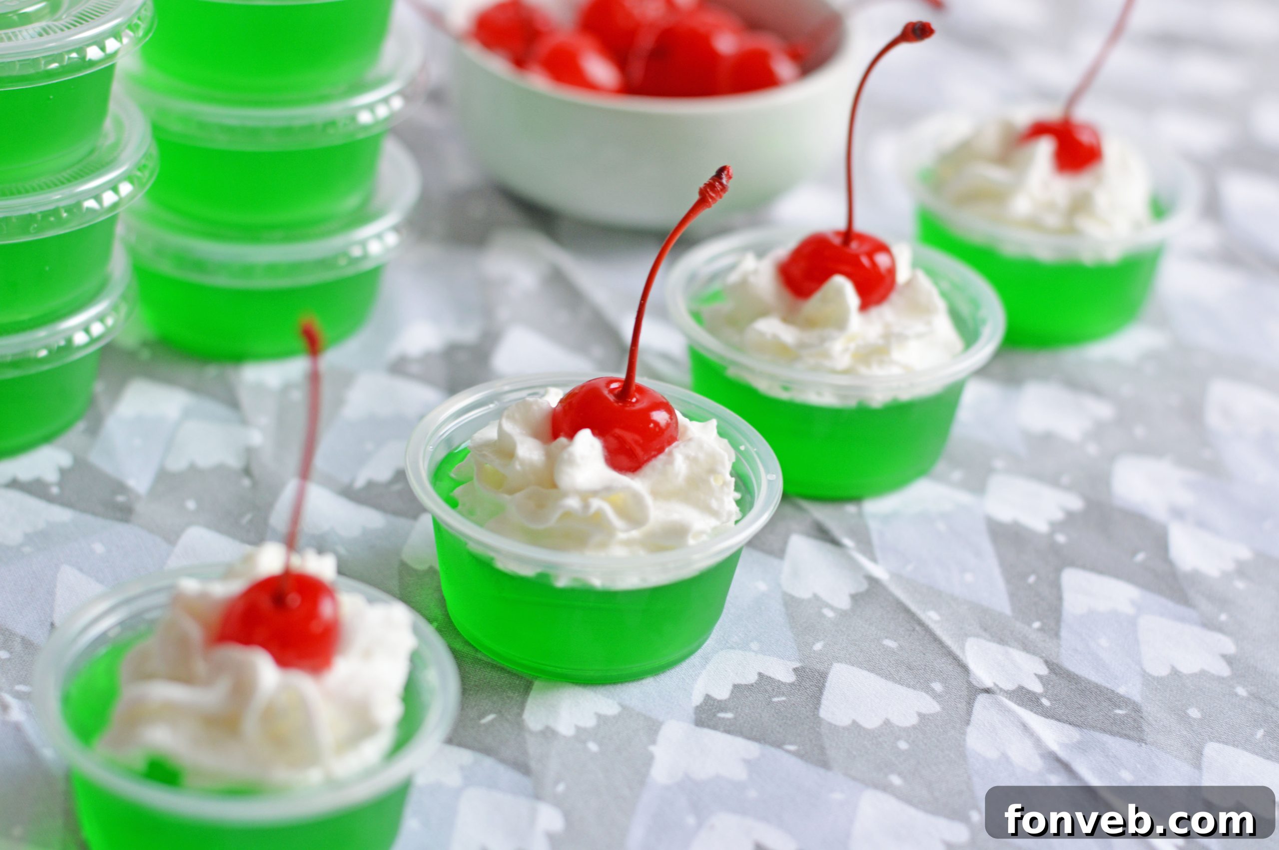 Grinch Jello Shots arranged on a festive tray with holiday decorations