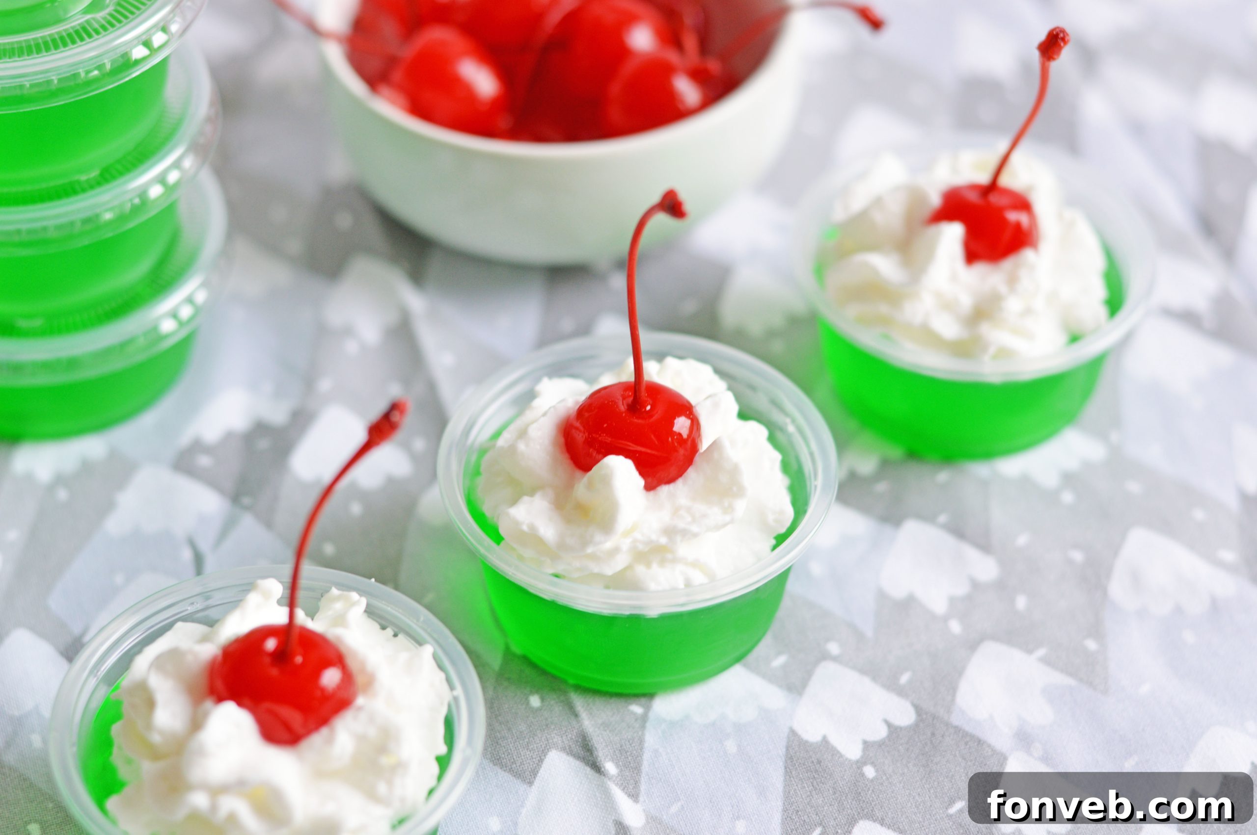 Grinch Jello Shots presented on a rustic wooden board