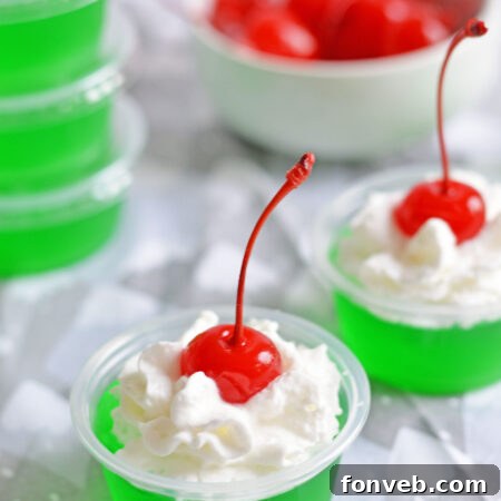 Grinch Jello Shots with whipped cream and cherry topping