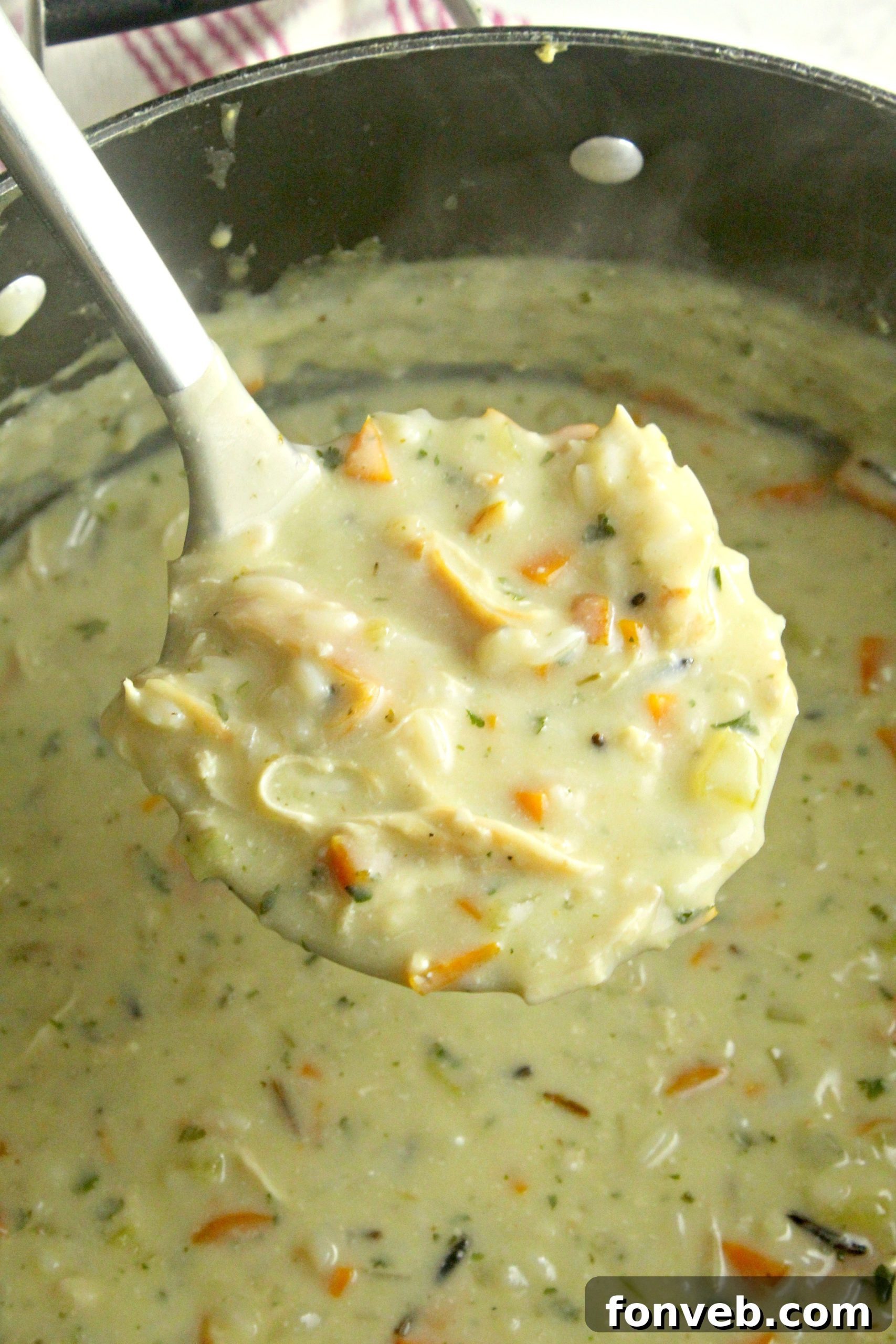 A bowl of creamy Panera-style chicken and wild rice soup, garnished with fresh herbs.