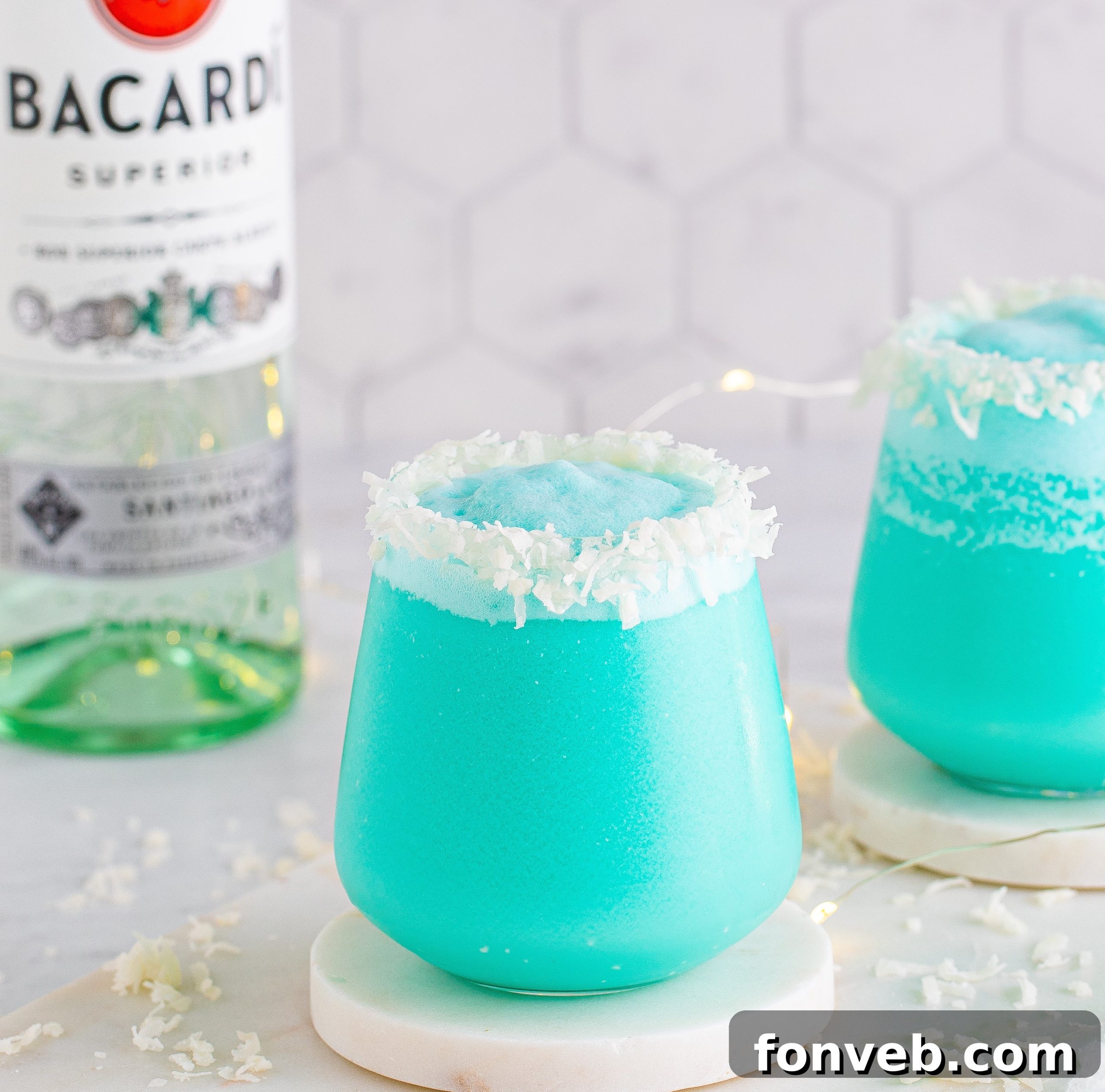 A beautifully presented Jack Frost Cocktail, glistening with a coconut rim and vibrant blue, ready to be enjoyed.