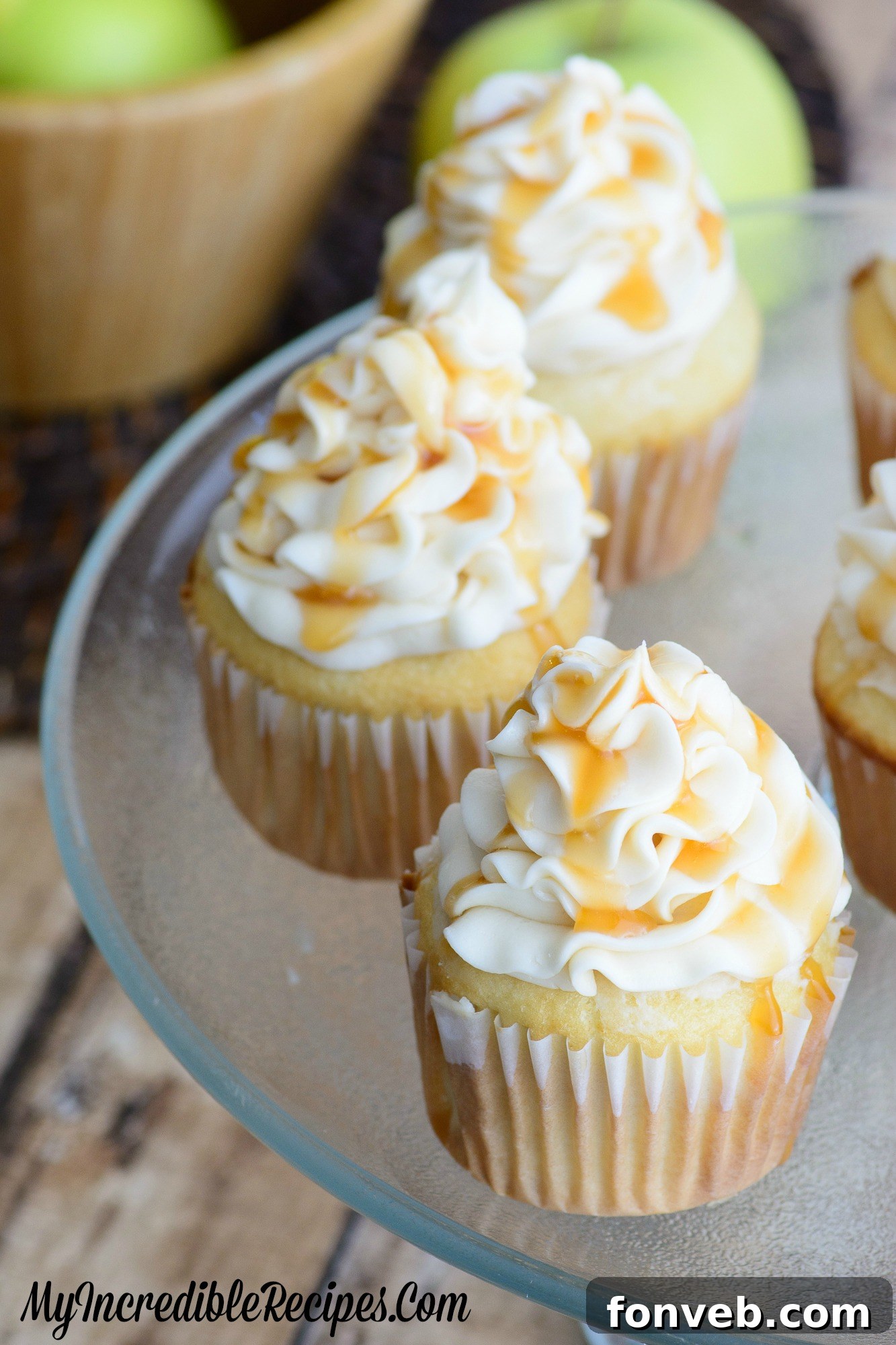 A single caramel apple cupcake shown from a side angle, highlighting its moist texture and rich frosting.