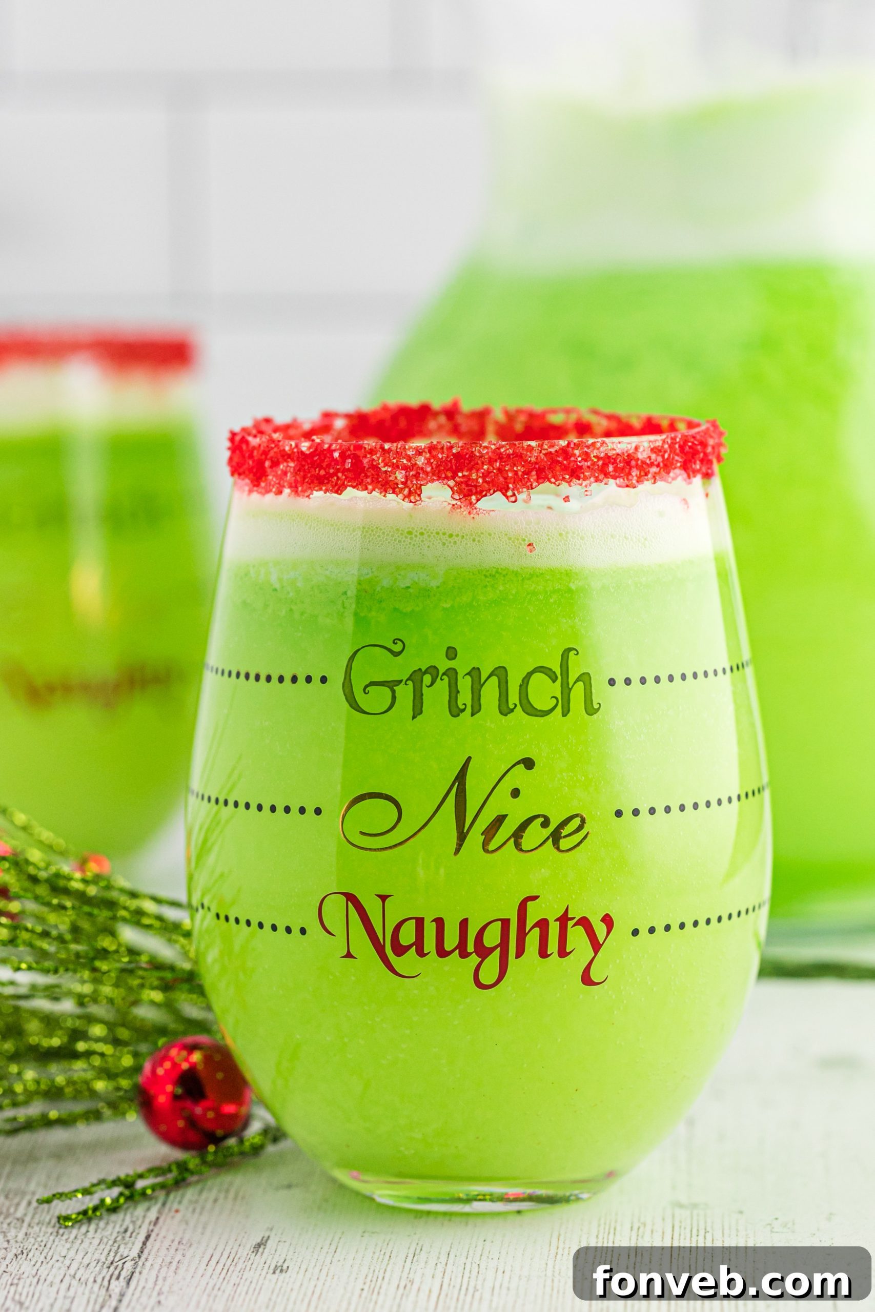 A large bowl of bright green Grinch Punch with scoops of lime sherbet floating on top, ready for serving.