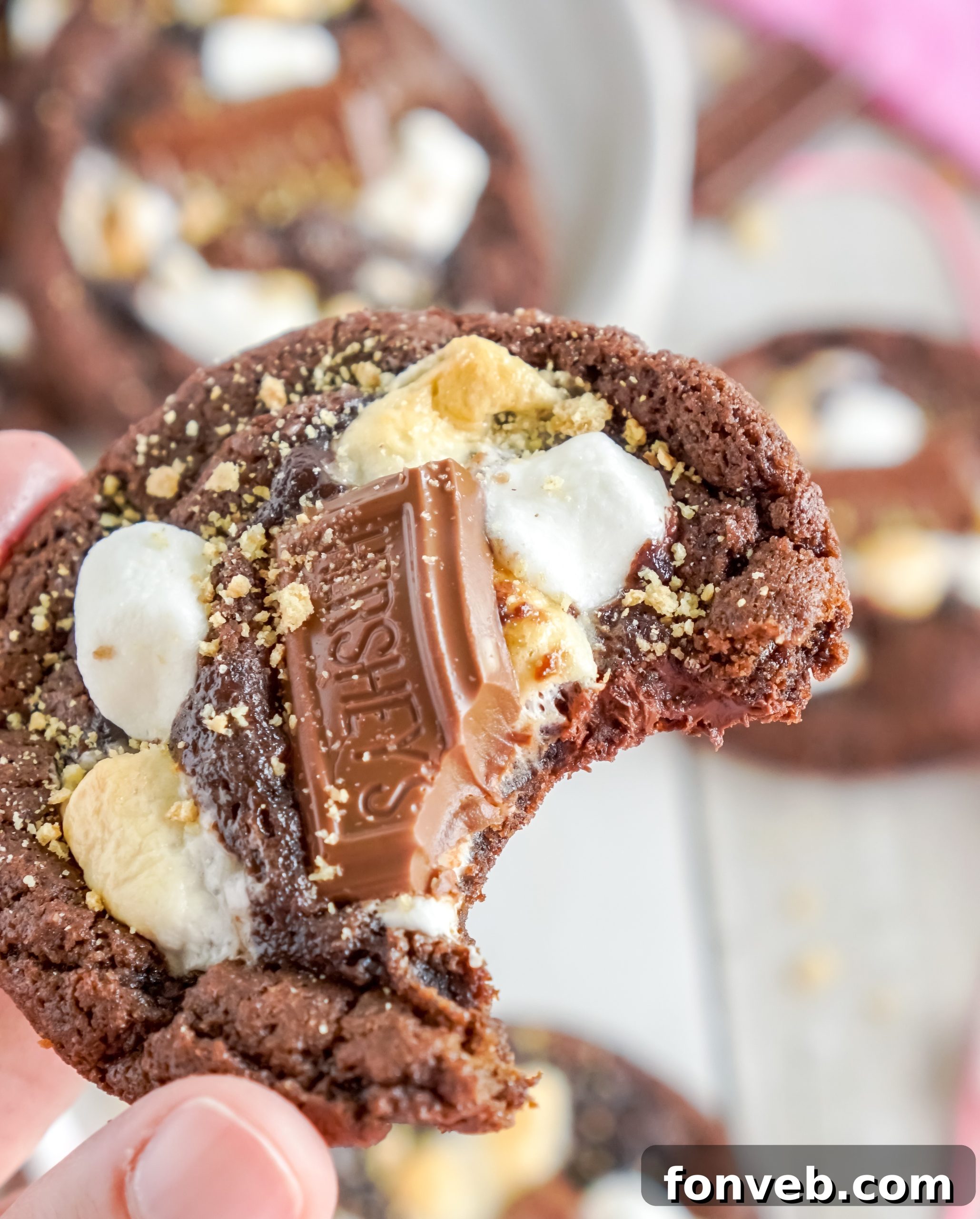 Several Hershey's Chocolate S'mores Cookies on a rustic wooden surface
