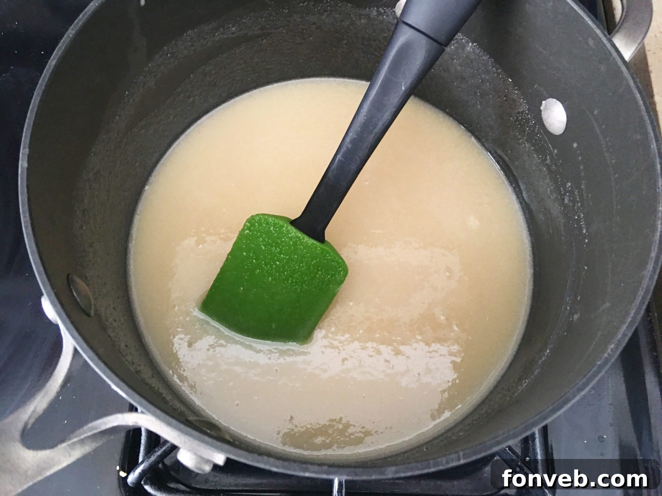 A close-up of a single piece of Unicorn Fudge, showcasing the intricate swirl of vibrant pink, orange, green, and blue, with a smooth, glossy finish.