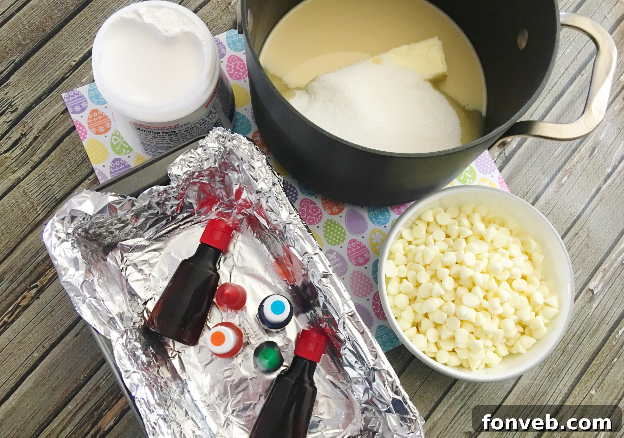 A large slab of freshly made Unicorn Fudge cooling in a foil-lined loaf pan, before being cut into individual pieces, showing the full rainbow spectrum.