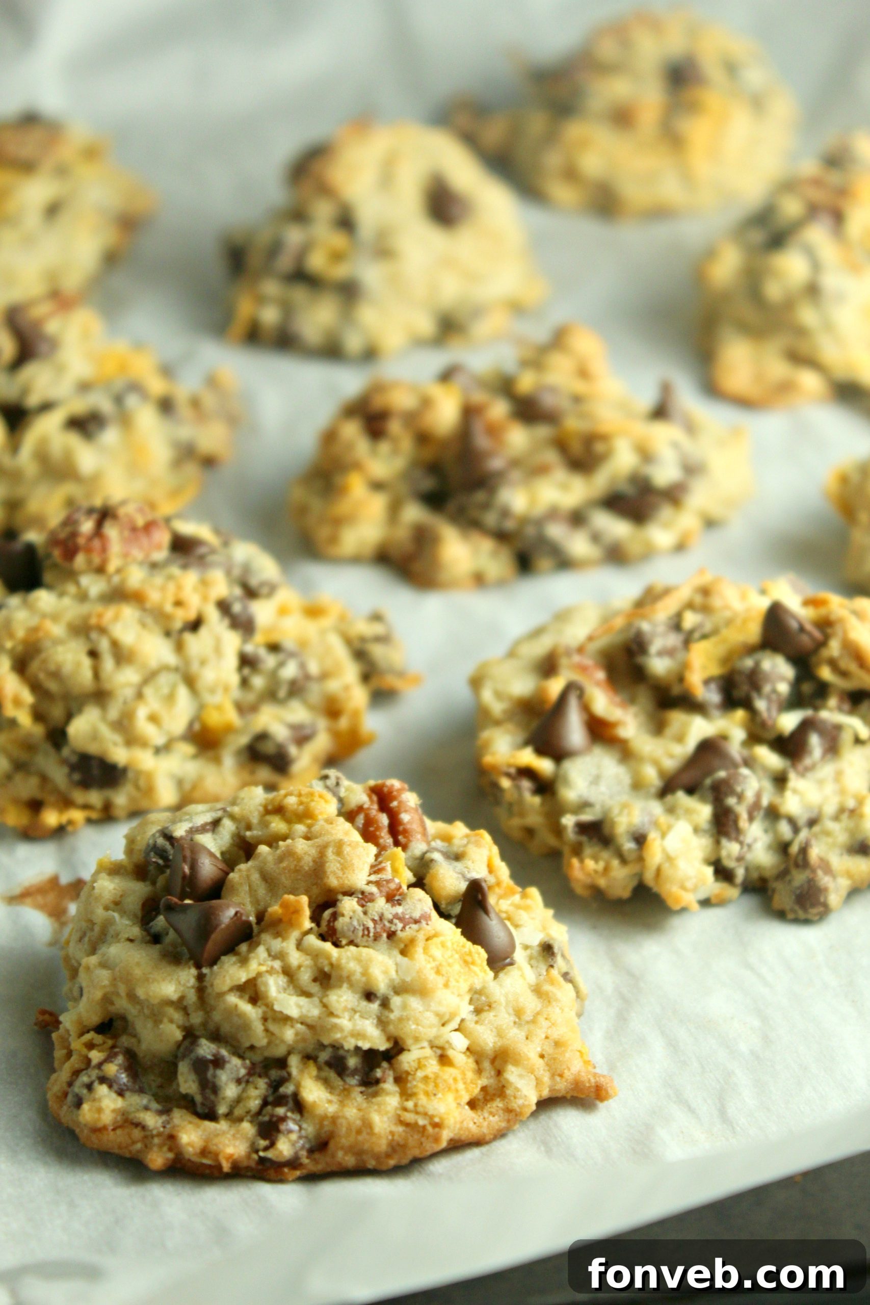 Stack of warm Cowboy Cookies on a rustic wooden surface, highlighting the melt-in-your-mouth chocolate and visible oats.