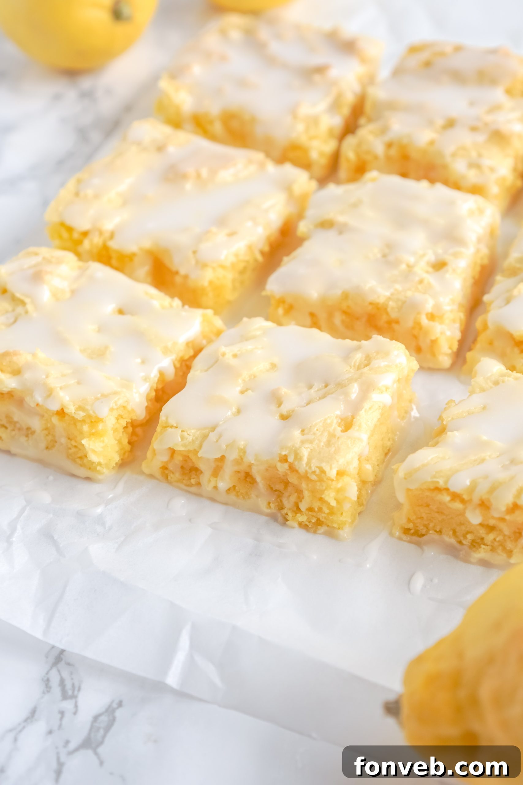 Close-up of a perfectly glazed lemon brownie, showing its moist texture and vibrant yellow color, ready to be enjoyed.