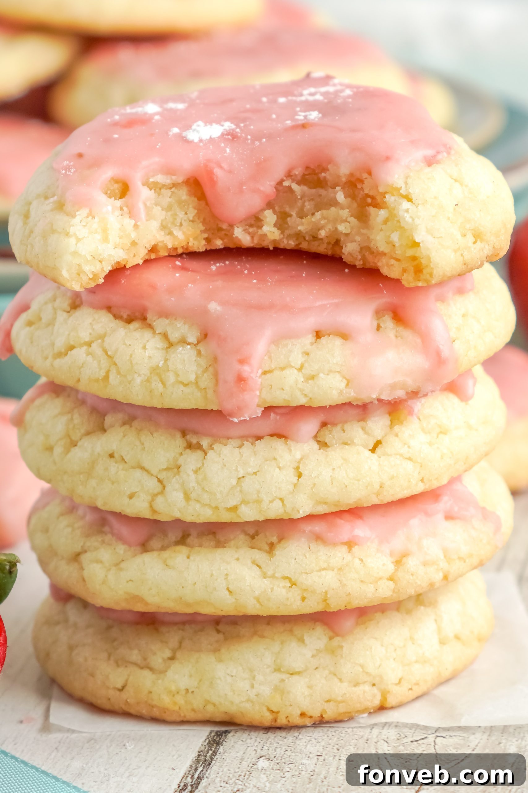 A close-up of a single perfect strawberry glazed sugar cookie, emphasizing its delightful appearance.