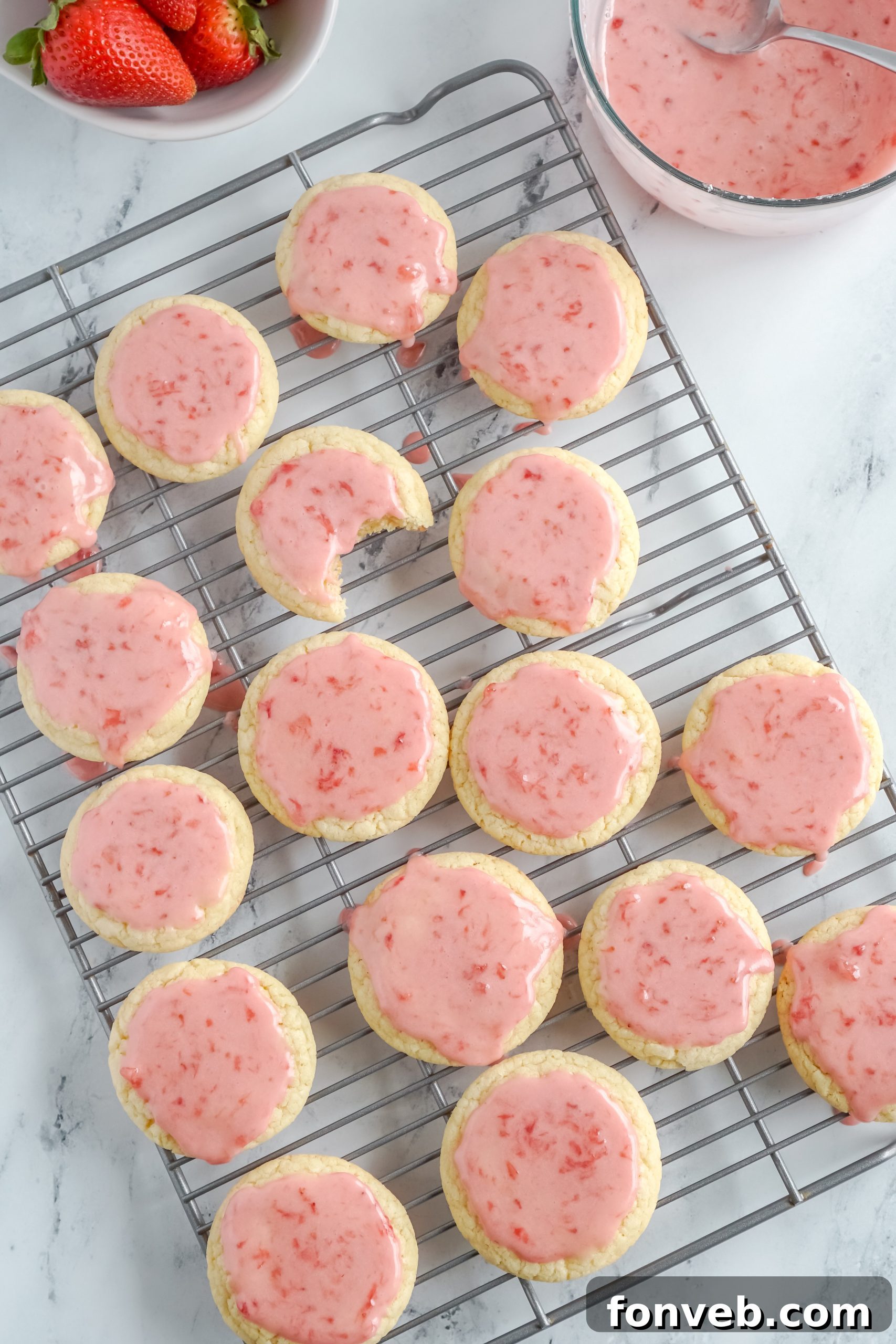 Three sugar cookies with strawberry glaze, stacked artfully, ready to be enjoyed.