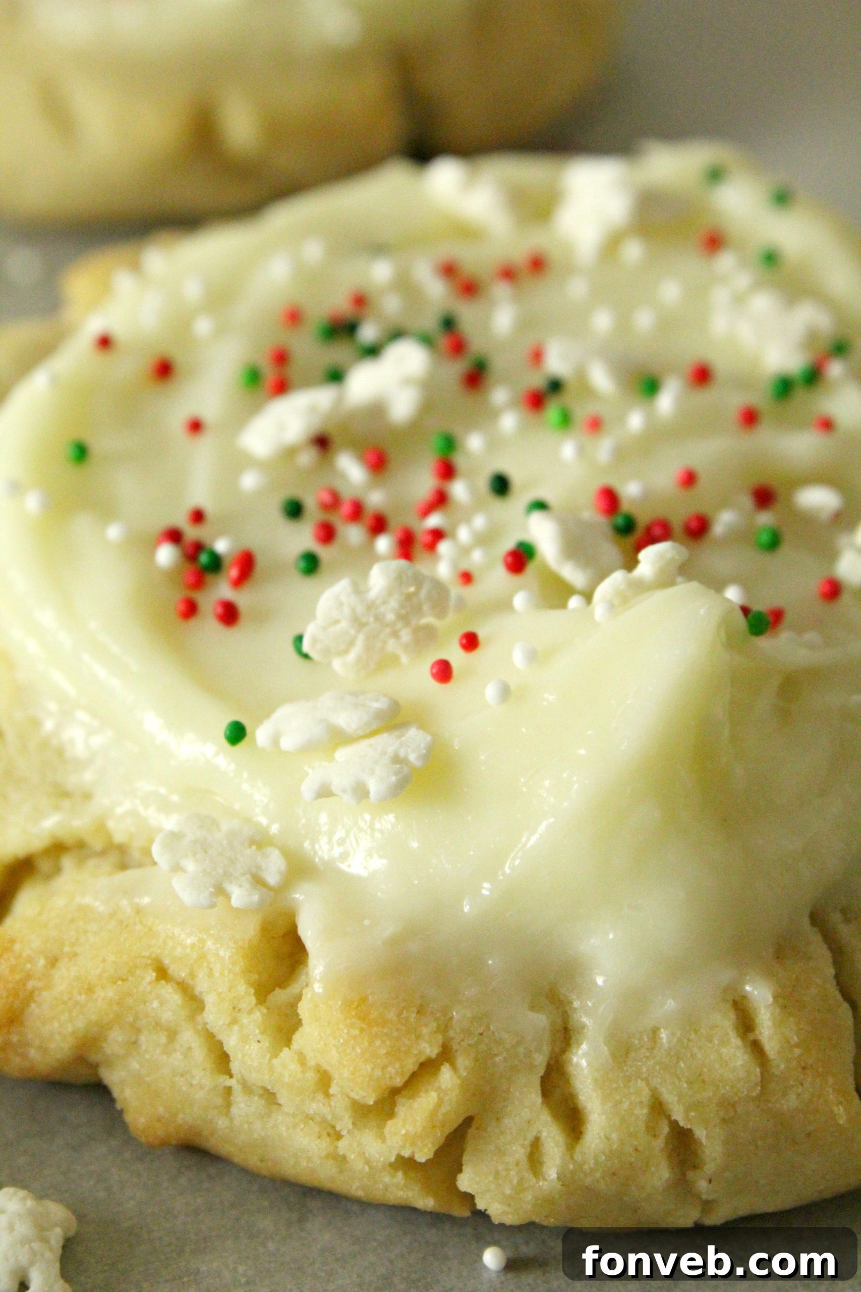 A freshly baked Swig Sugar Cookie with pink frosting and sprinkles, held up close to the camera.