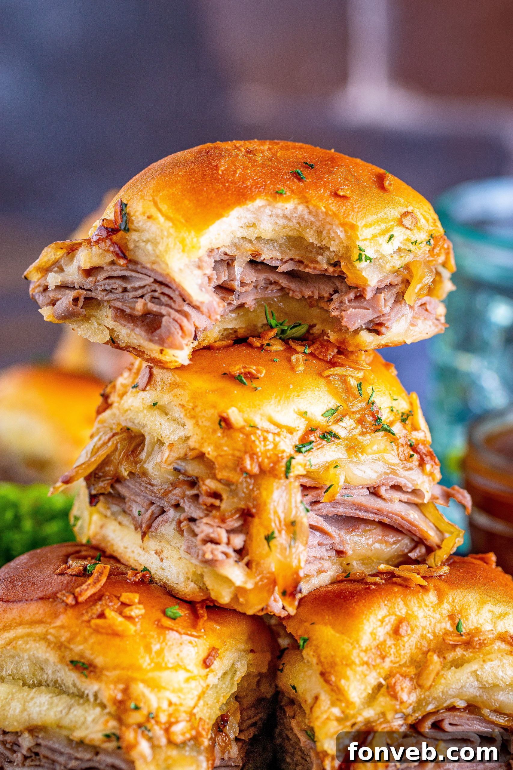 Dunkable French Dip Sliders 11 French Dip Sliders piled with the top having a bite taken