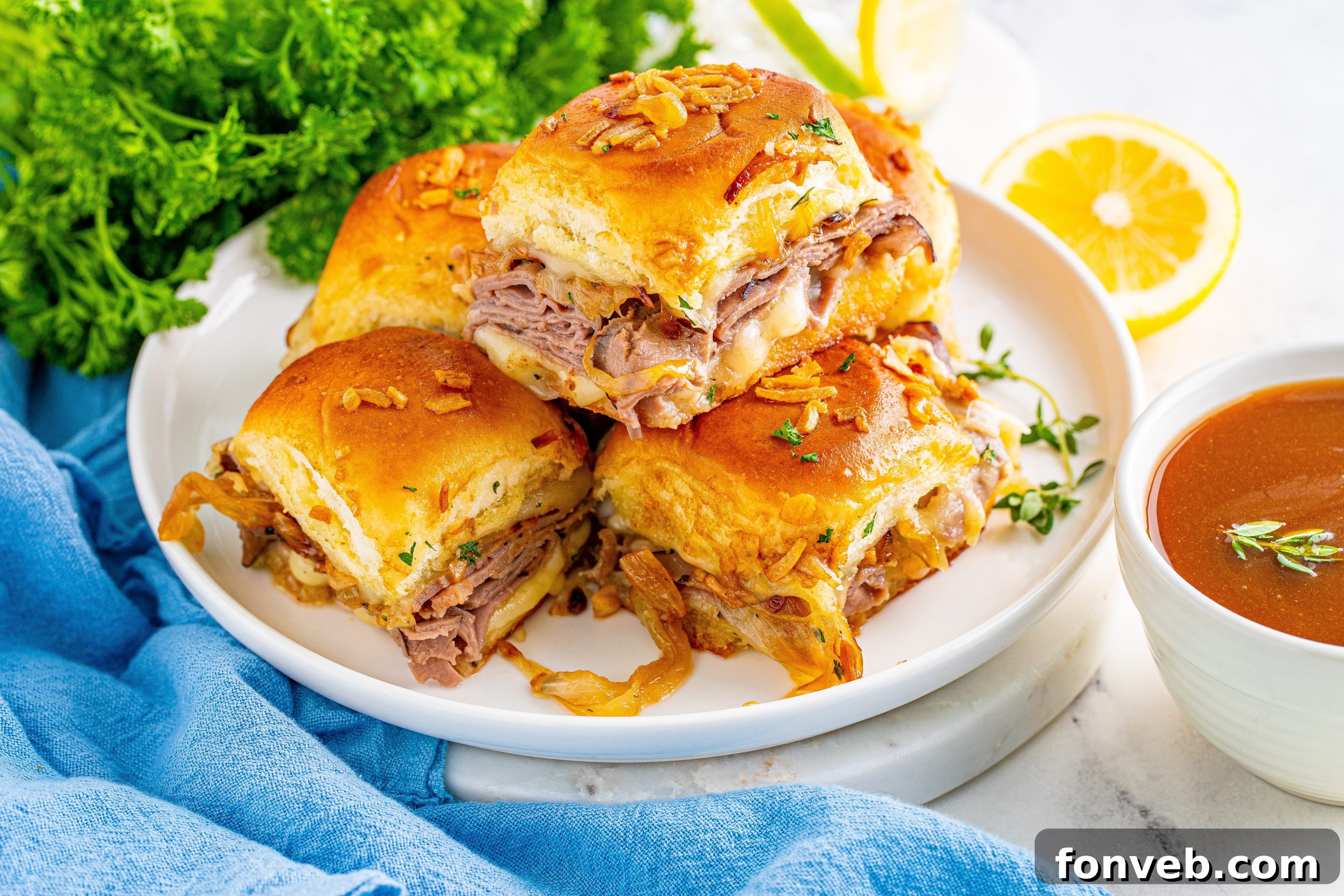 Dunkable French Dip Sliders 8 French Dip Sliders piled on a white plate