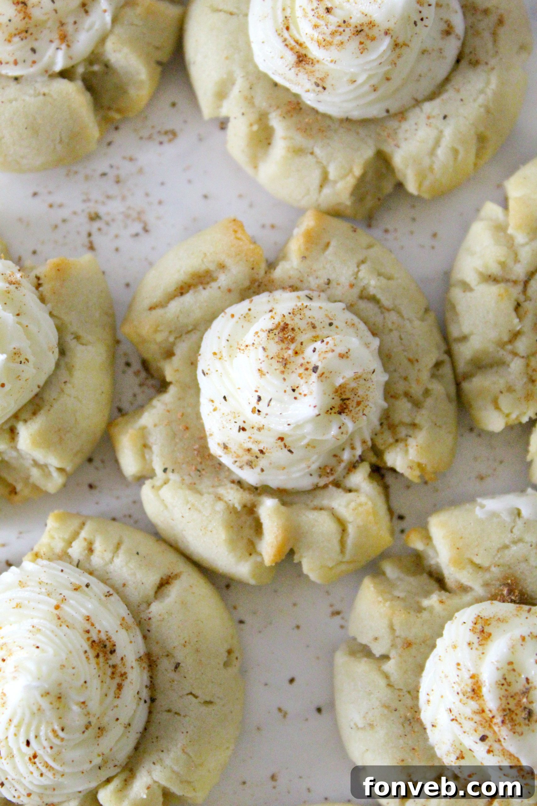Process shot of shaping Eggnog Thumbprint Cookies before baking.