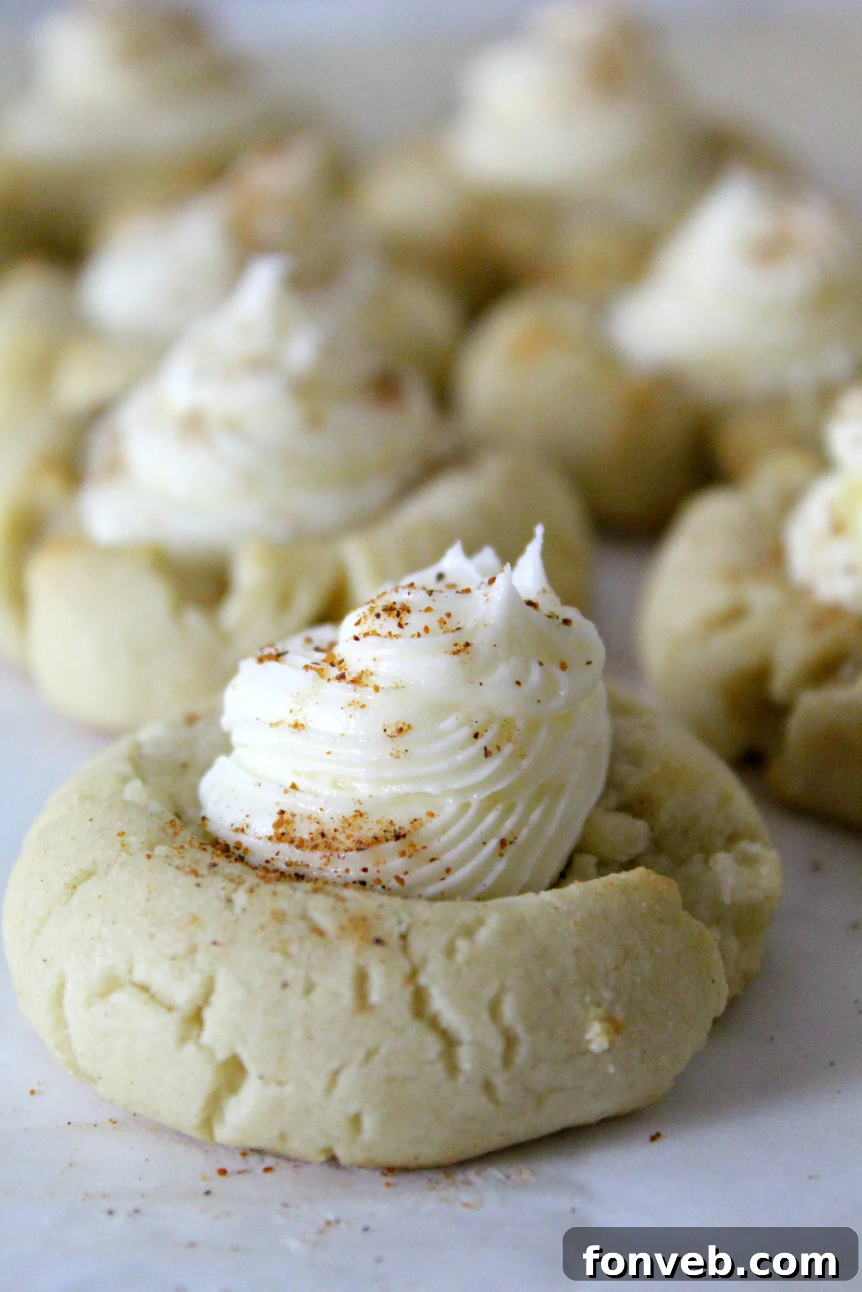 Eggnog Thumbprint Cookies with rum frosting arranged beautifully on a plate.