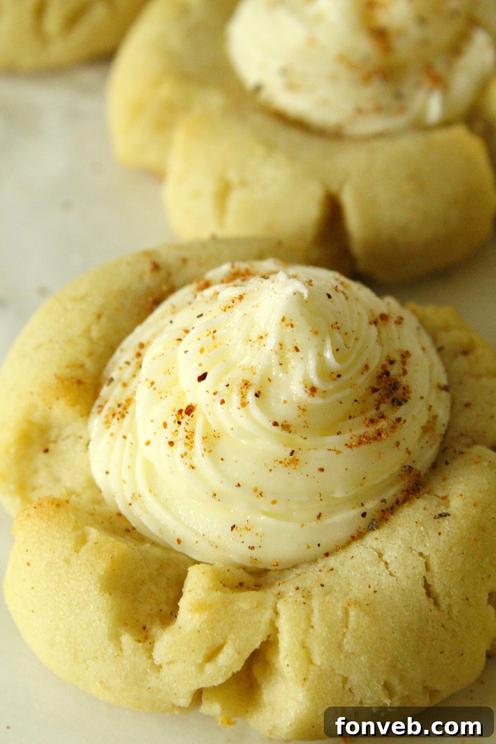 Beautifully arranged Eggnog Thumbprint Cookies on a white plate, ready to be served.