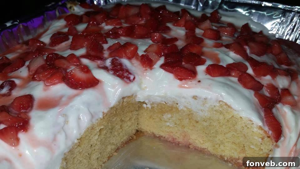 Fully assembled strawberry shortcake with abundant frosting and berries