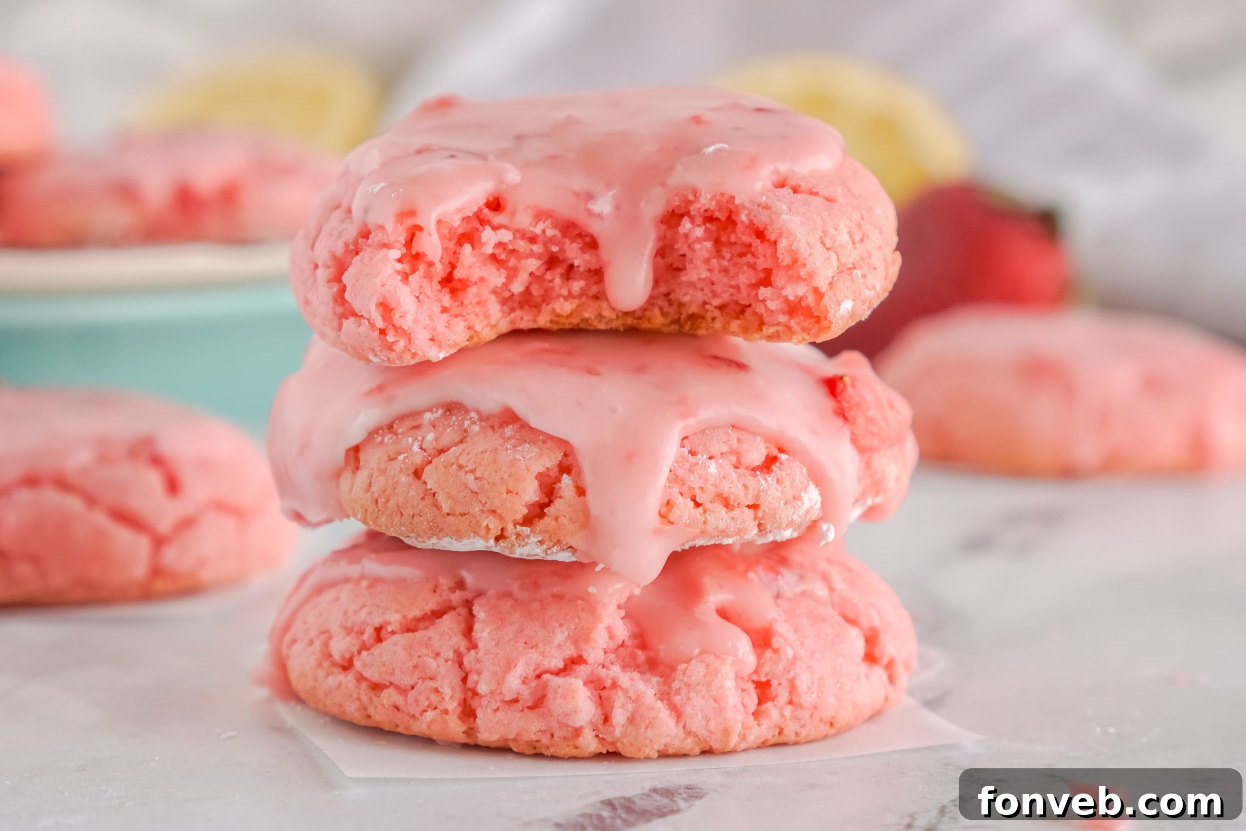 Multiple strawberry cookies arranged on a white plate, showcasing their texture and glaze.