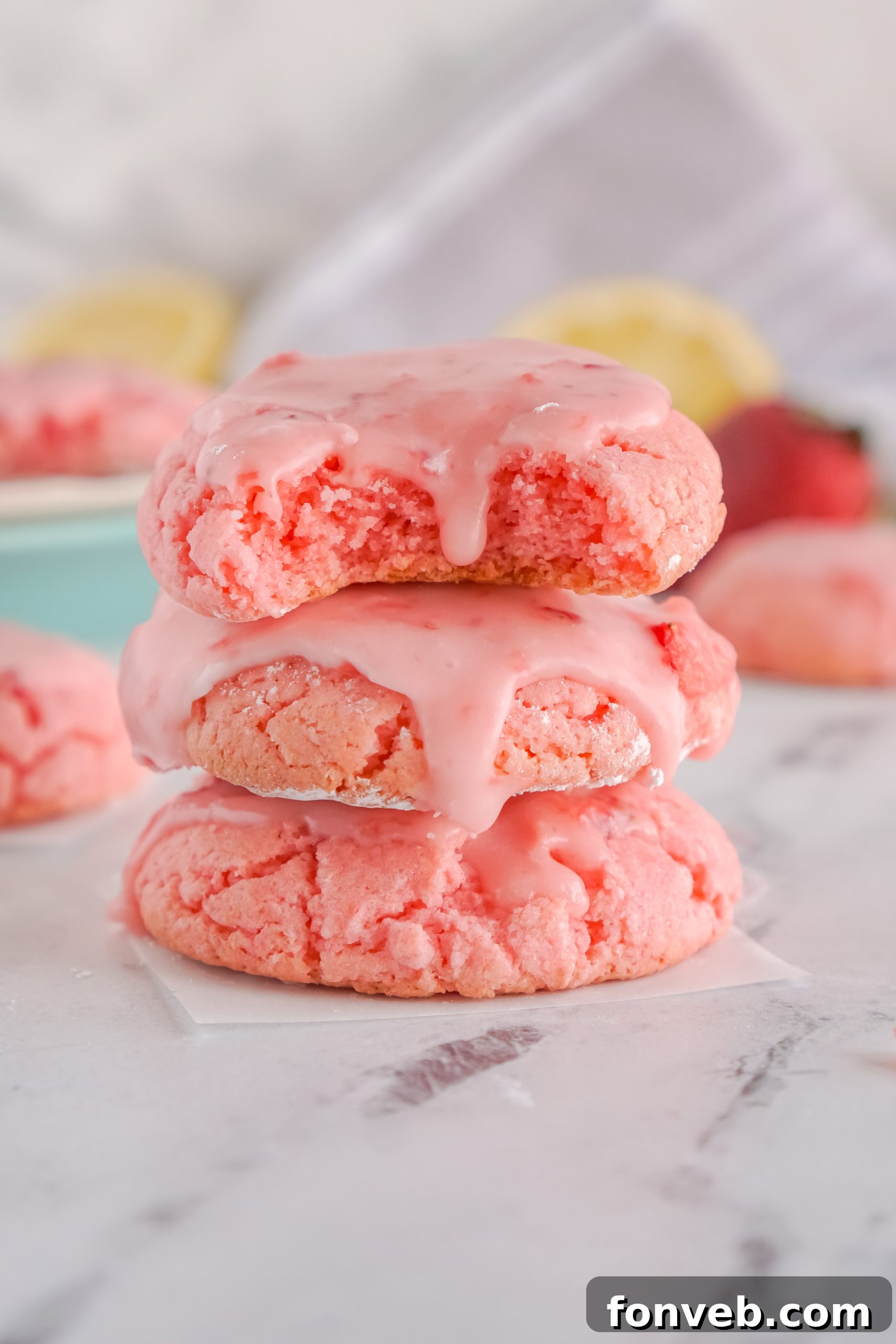 Another angle of cooling glazed strawberry cookies on a rack.