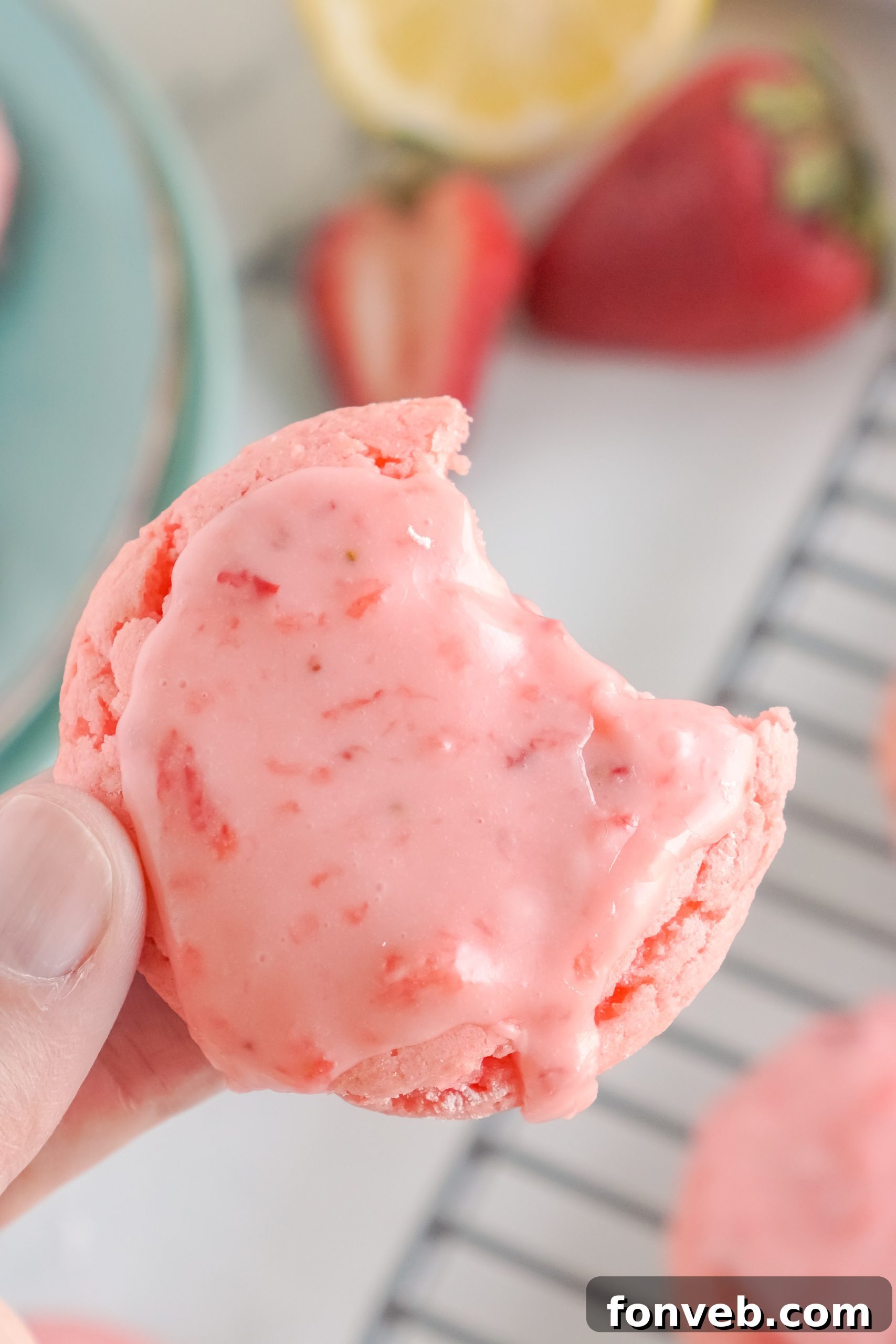 Close-up of a single glazed strawberry cookie on a baking tray.