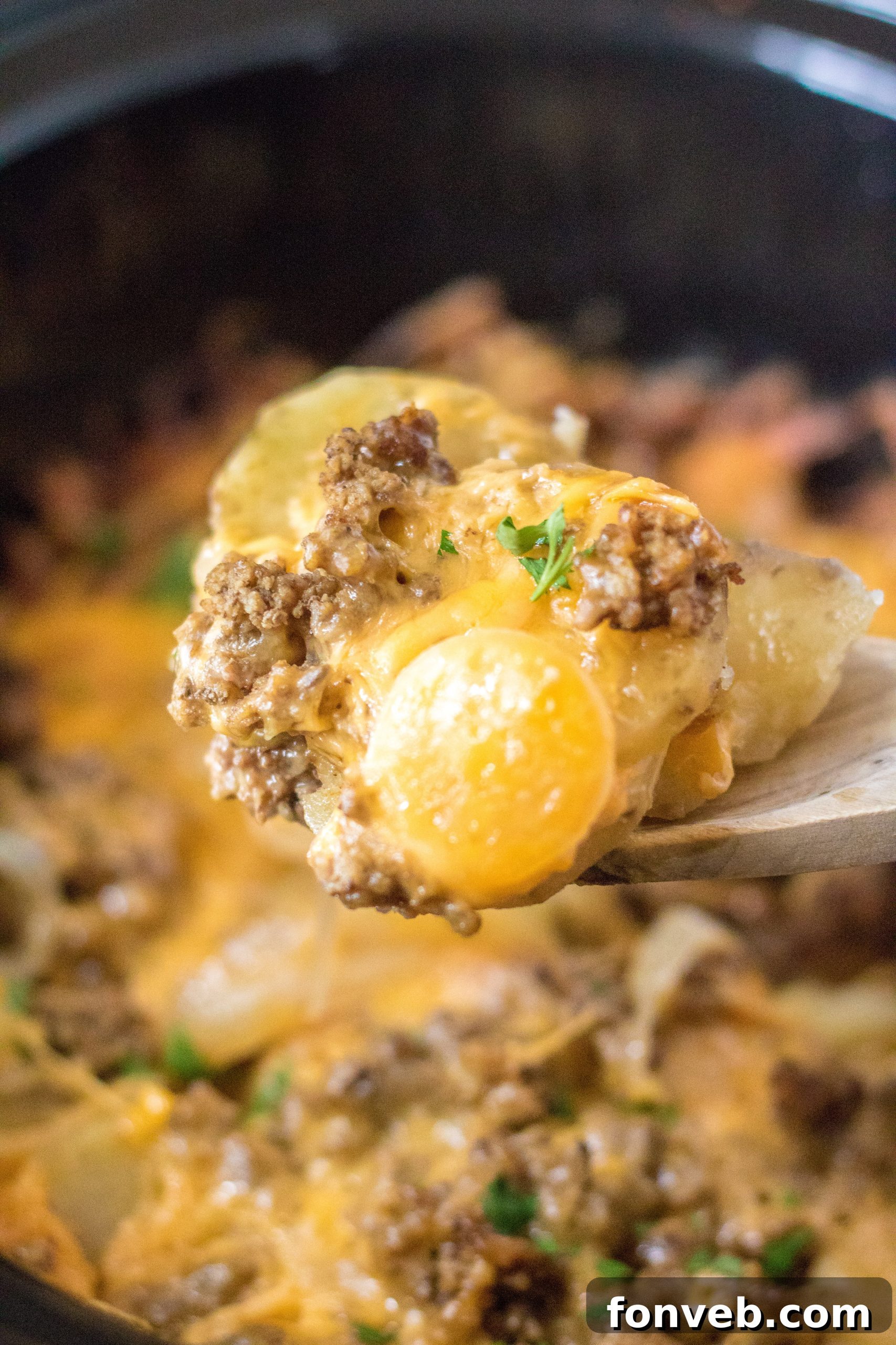 A top-down view of the ingredients for Slow Cooker Beef and Potato Au Gratin, including sliced potatoes, ground beef, and onions.