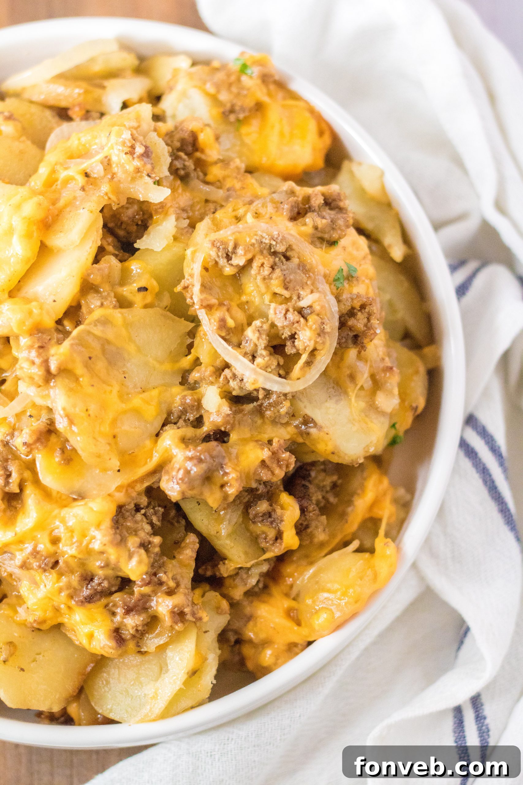 The Slow Cooker Beef and Potato Au Gratin simmering, with cheese melting on top, indicating it's nearly ready.